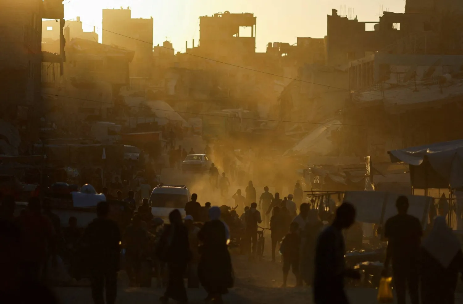 People walk at the remains of a market after an Israeli strike, amid the ongoing conflict between Israel and Hamas, in Khan Younis, in the southern Gaza Strip, June 30, 2024. REUTERS/Mohammed Salem
