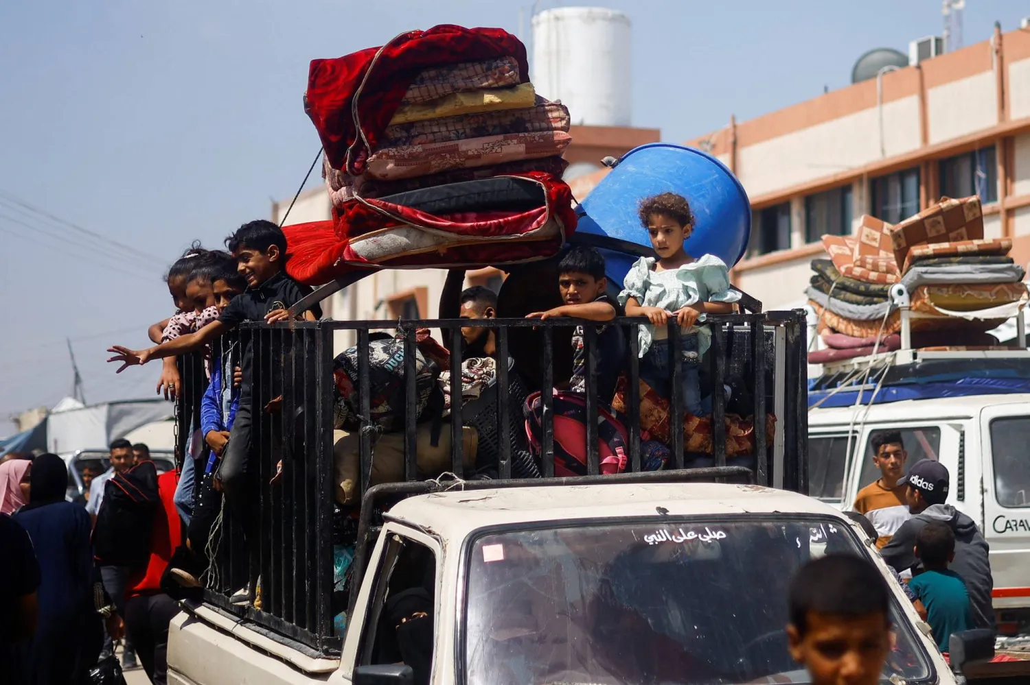 Palestinians, who fled the eastern part of Khan Younis after they were ordered by Israeli army to evacuate their neighborhoods, ride on a pickup truck loaded with belongings, amid Israel-Hamas conflict, in Khan Younis in the southern Gaza Strip July 2, 2024. REUTERS/Mohammed Salem