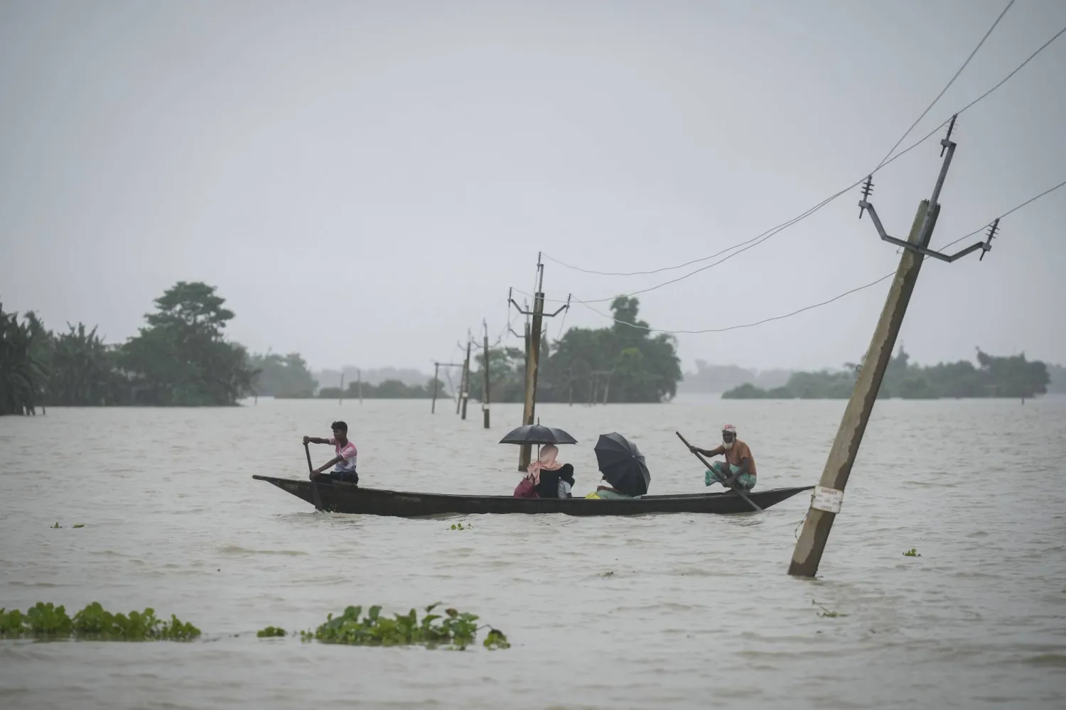Flood affected people travel with their belongings through flood waters in Sildubi village in Morigaon district in the northeastern state of Assam, India, Tuesday, July 2, 2024. (AP photo/Anupam Nath)
