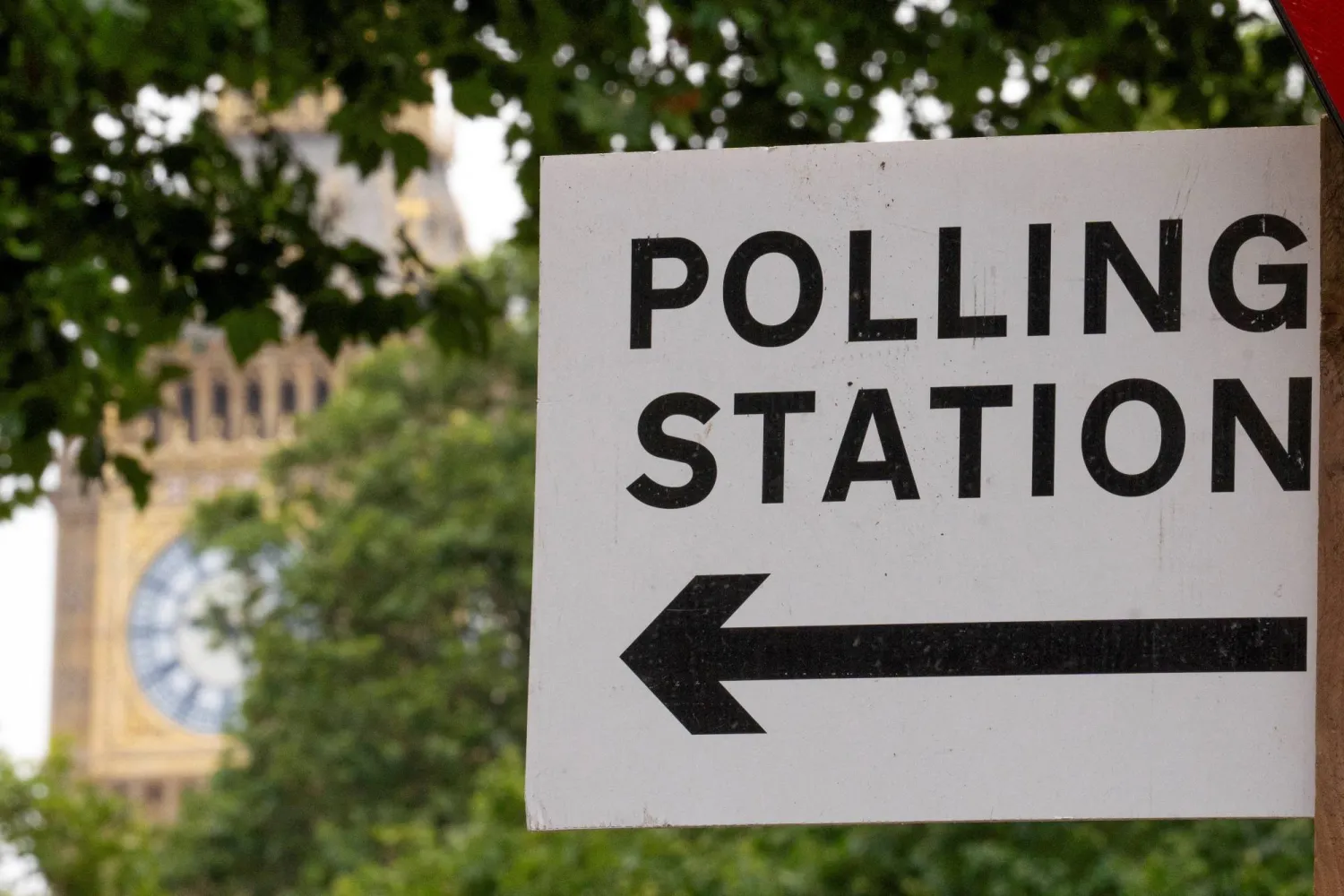 FILE PHOTO: A polling station direction sign is attached to a street sign near the Elizabeth Tower, more commonly known as Big Ben, ahead of general elections, in London, Britain July 3, 2024. REUTERS/Maja Smiejkowska/File Photo