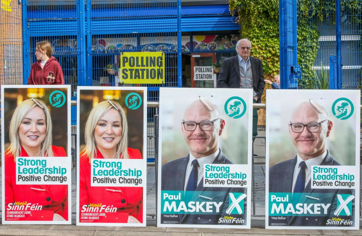 يغادر الناخبون مركز اقتراع بمدرسة سانت تيريزا الابتدائية في بلفاست (أ.ف.ب)