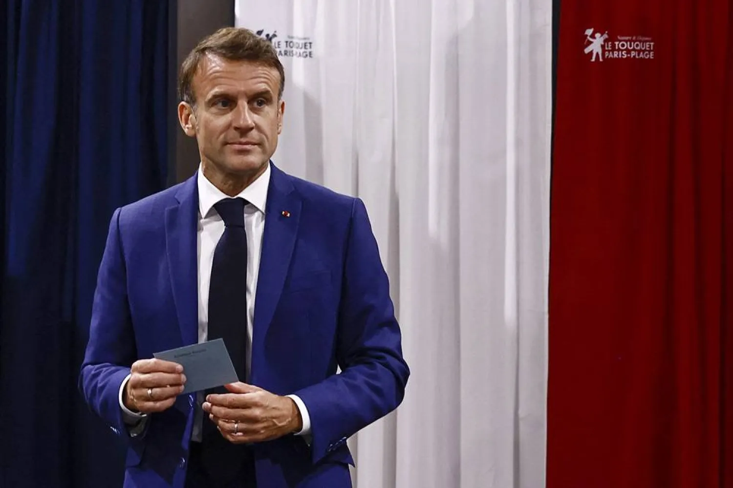 French President Emmanuel Macron leaves the voting booth before voting in the early French parliamentary election, in Le Touquet-Paris-Plage, northern France, Sunday, June 30, 2024. (AP)