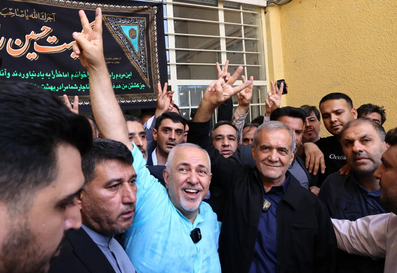 Pezeshkian and former foreign minister Mohammad Javad Zarif raising victory sign after election results - EPA