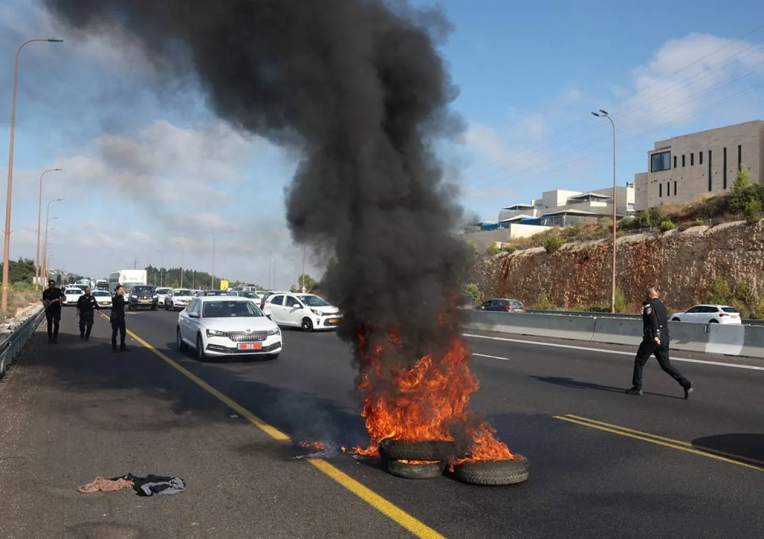  Israeli police work to extinguish a fire lit by anti-government protestors on a day of protests marking 9 months since the deadly October 7 attack, under the slogan "Israel comes to a standstill", near Shoresh, Israel, July 7, 2024. (Reuters)