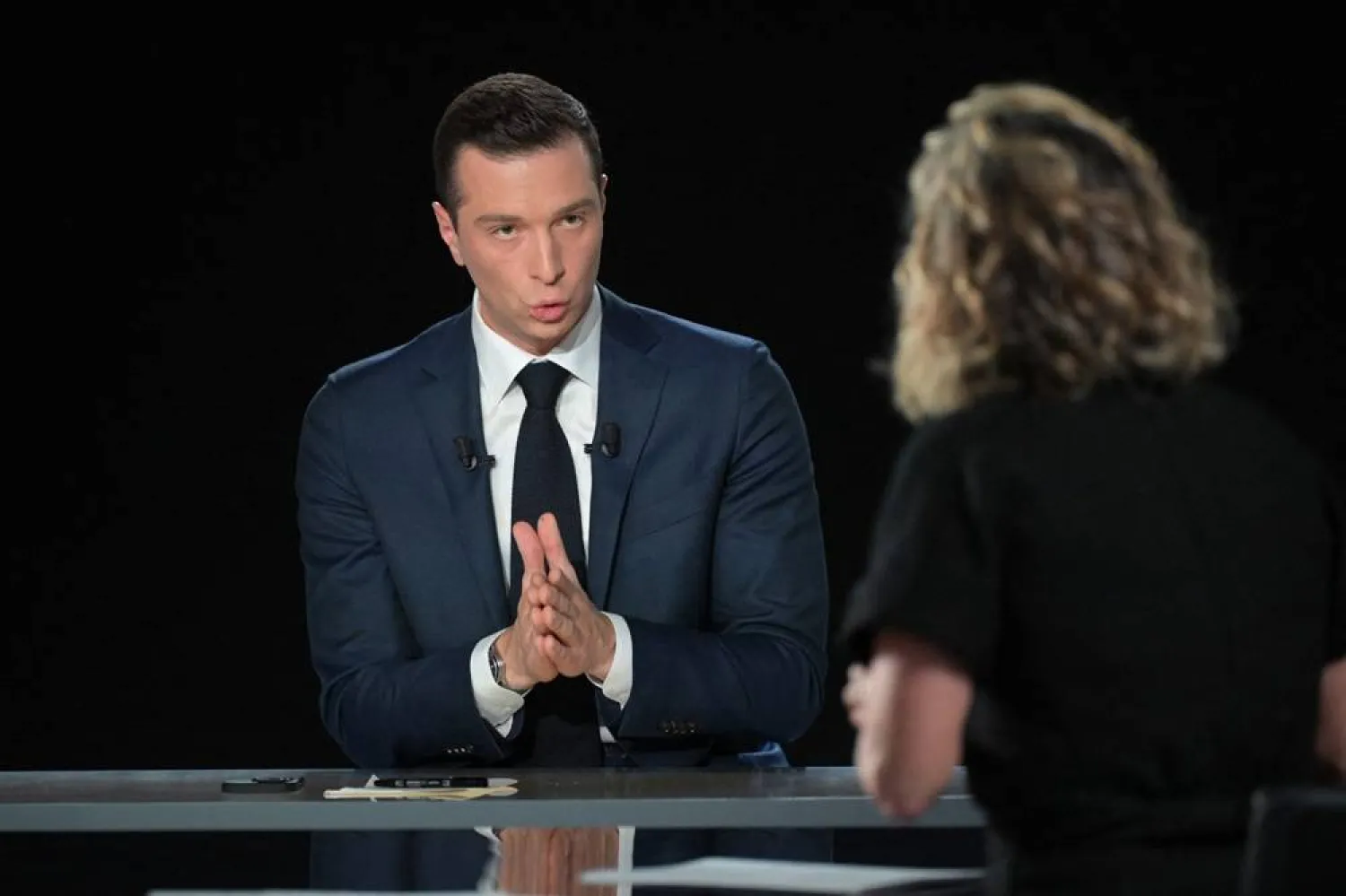  French far-right Rassemblement National (RN) political party President and lead MEP Jordan Bardella (L) answers to French journalist Caroline Roux during the TV show "L'Evenement" broadcasted on French TV channel France 2 in Paris on July 4, 2024, ahead of the second round of the legislative elections. (AFP)