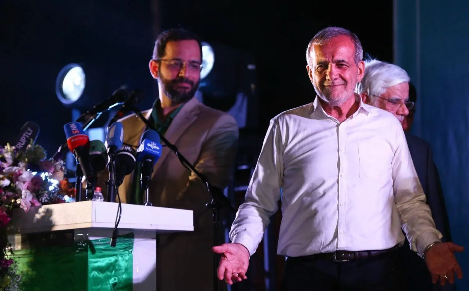 Burhani, Pezekiyan’ın geçtiğimiz çarşamba günü Şehid Haydarniya Stadyumu’ndaki son seçim mitingi sırasında sağında dururken (Jamaran)