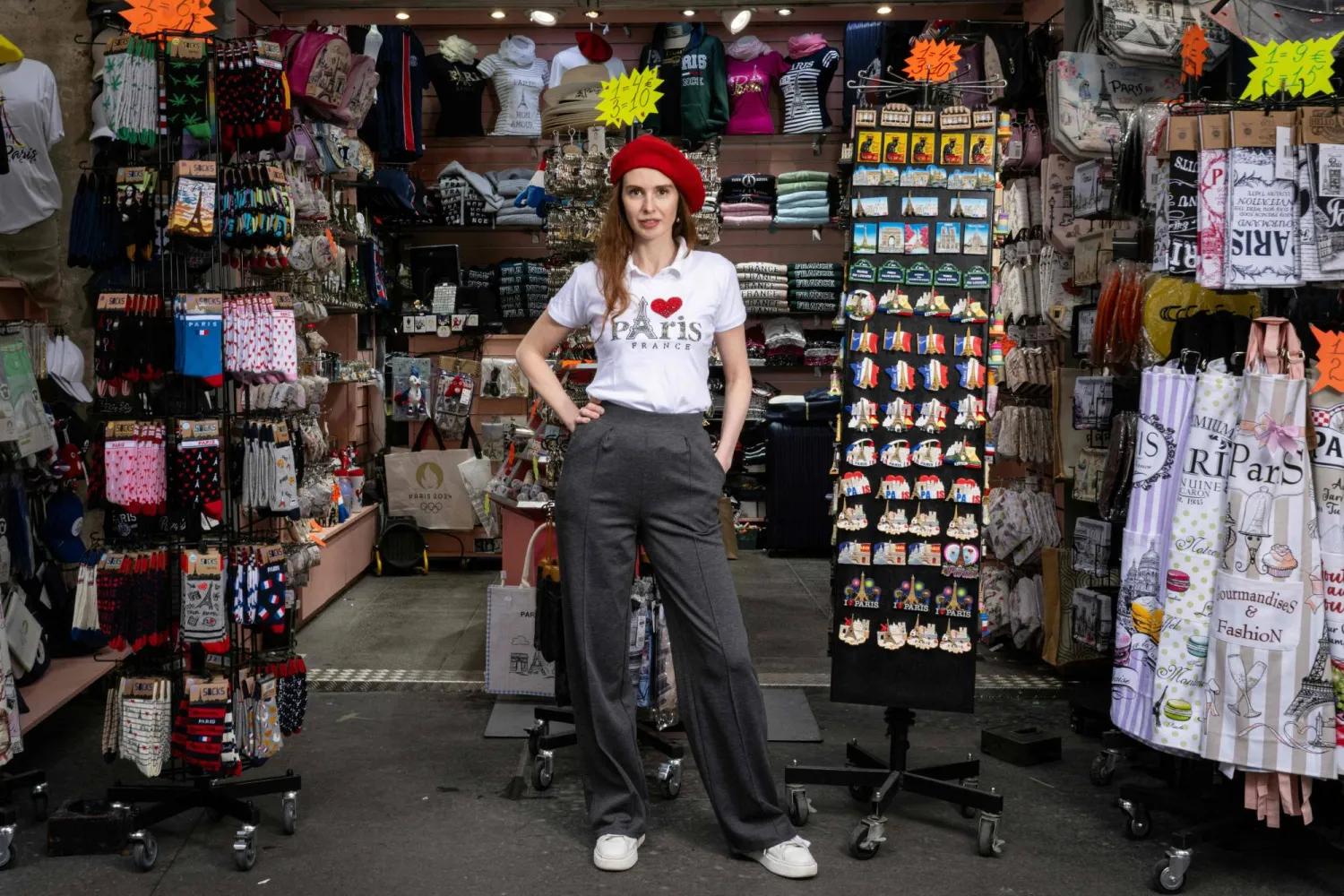 جالي صاحبة متجر «GM» للهدايا التذكارية للمسافرين والسياح وهي تقف أمام متجرها في شارع «ريفولي» في باريس (أ.ف.ب)