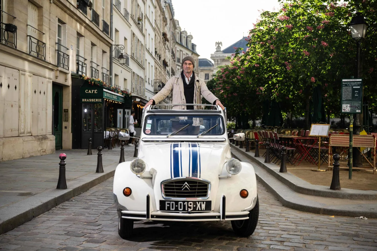 السائق الفرنسي إيريك لـ«2 CV Paris Visits» الذي يقترح استكشاف العاصمة الفرنسية بسيارته الشهيرة «Citroen 2 CV» (أ.ف.ب)