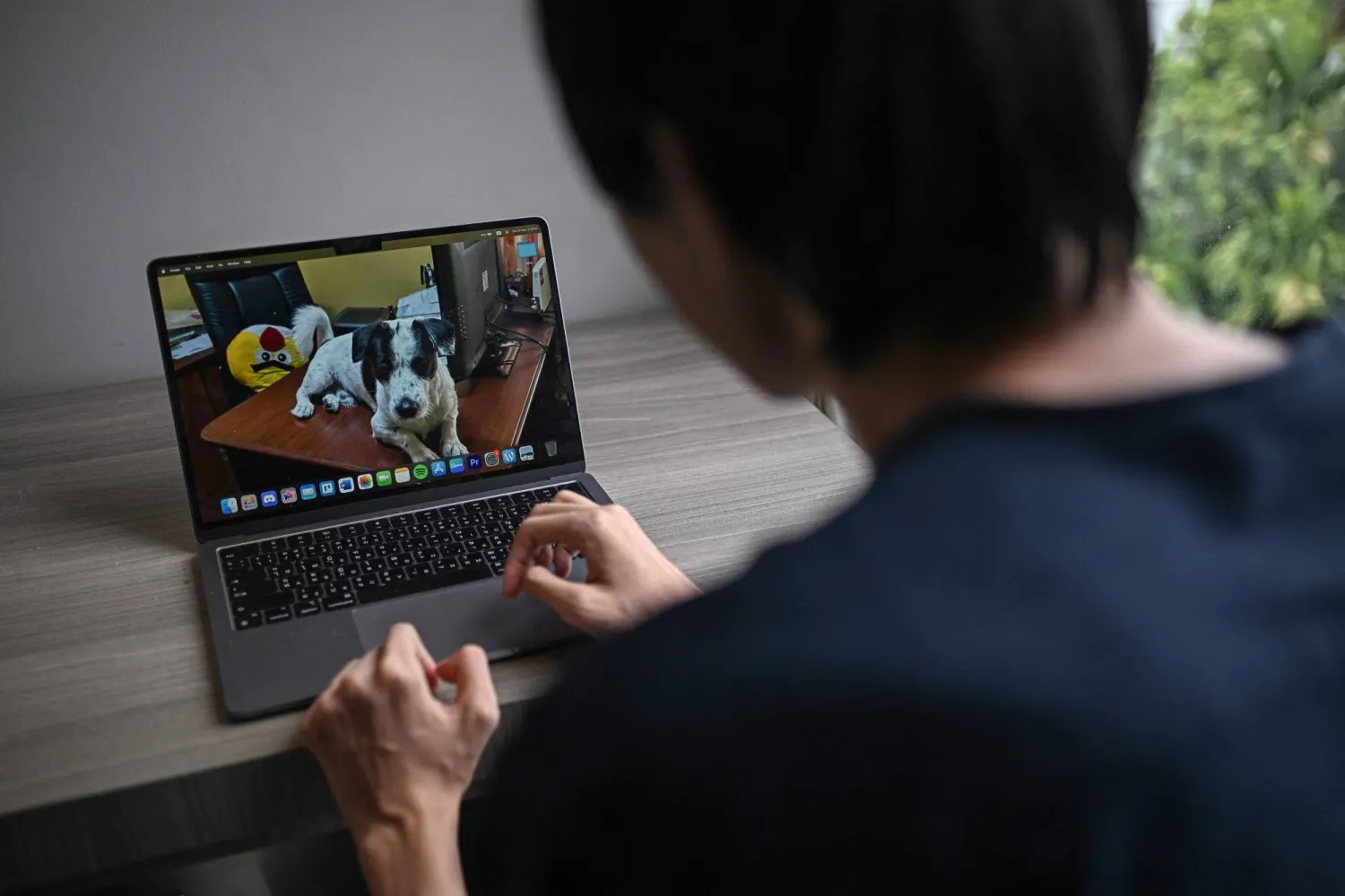 شخص يعمل على جهاز الكمبيوتر المحمول الخاص (أ.ف.ب)