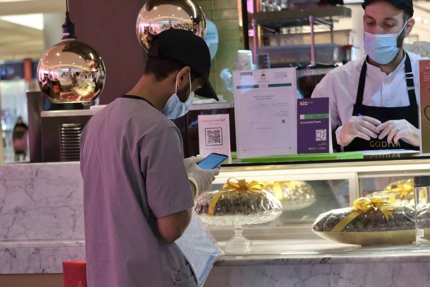 موظف شركة «إجادة» يمارس مهام التفتيش في أحد المحلات التجارية (الشرق الأوسط)