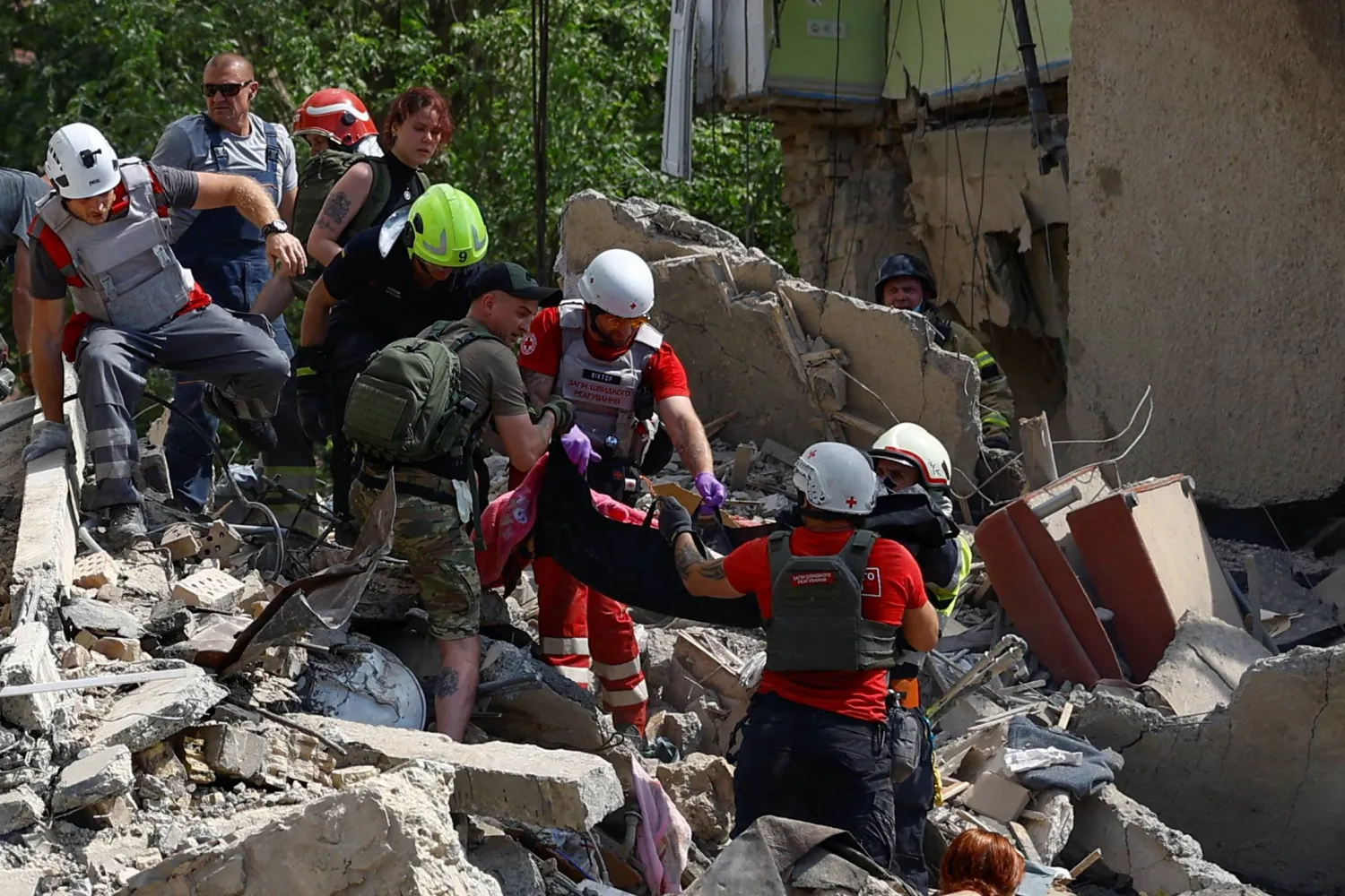 Rescuers and paramedics carry a body of a child found at a site an apartment building heavily damaged during a Russian missile strike, amid Russia's attack on Ukraine, in Kyiv, Ukraine July 8, 2024. REUTERS/Valentyn Ogirenko