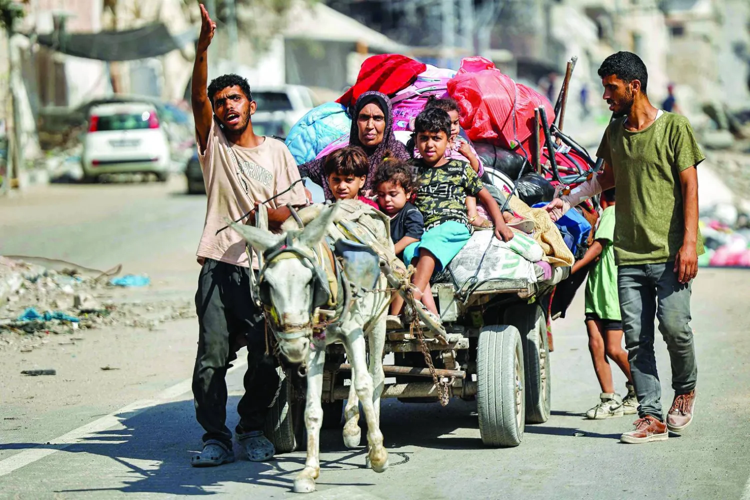 
نازحون فلسطينيون يحاولون العودة إلى منزلهم في منطقة التفاح بمدينة غزة أمس (أ.ف.ب)