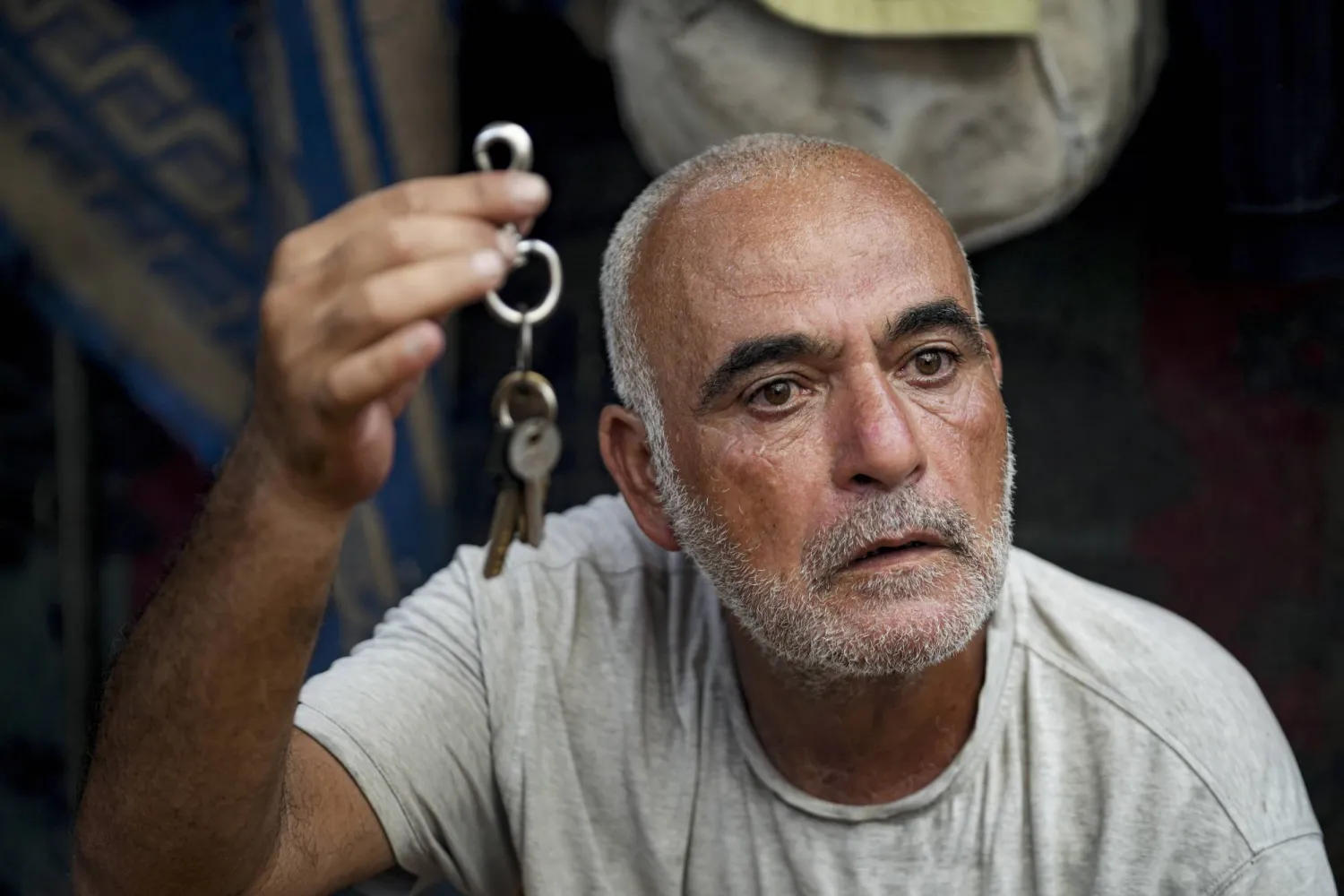 Hassan Nofal, 53, who was displaced by the Israeli bombardment of the Gaza Strip, holds the keys to his home that he was forced to leave with his family at a makeshift tent camp in Khan Younis, southern Gaza Strip, Thursday, July 4, 2024. (AP Photo/Abdel Kareem Hana)