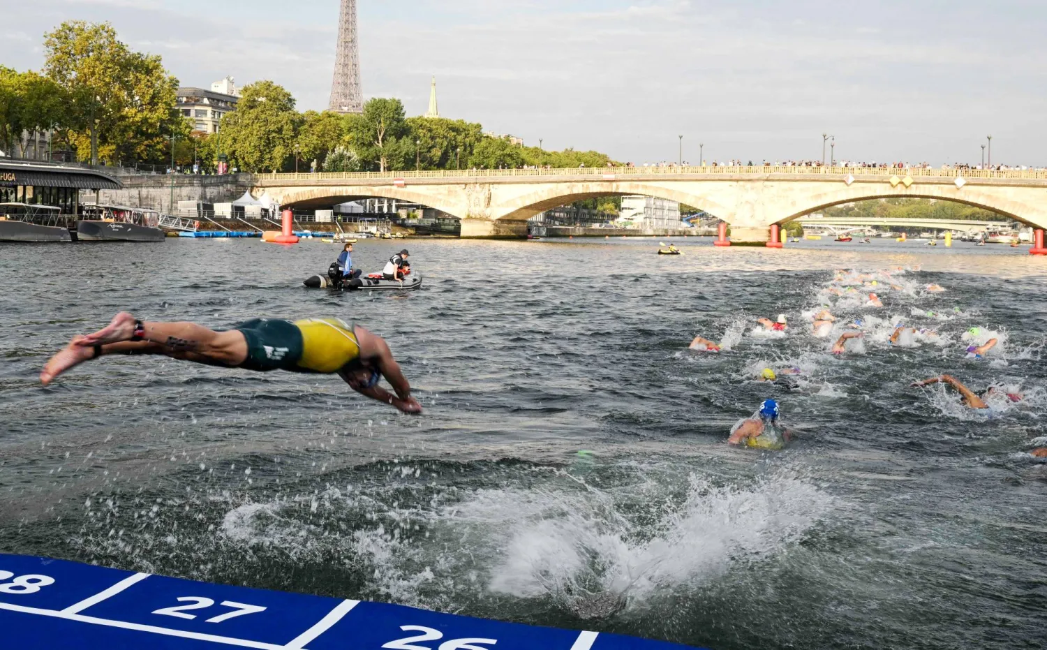 سبّاحون يغطسون في نهر السين خلال إجراء اختبارات لدورة الألعاب الأولمبية (أ.ف.ب)