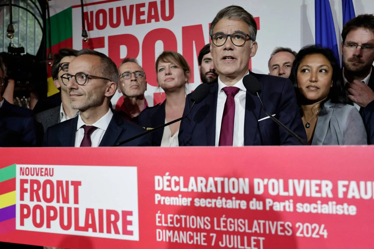 السكرتير الأول للحزب الاشتراكي اليساري الفرنسي أوليفييه فور (يمين) يلقي كلمة بعد الإعلان عن النتائج الأولية للانتخابات (أ.ف.ب)