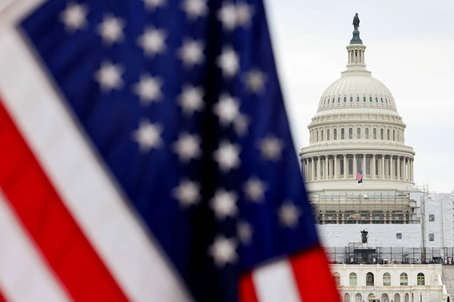 علم الولايات المتحدة ومبنى الكابيتول (رويترز)