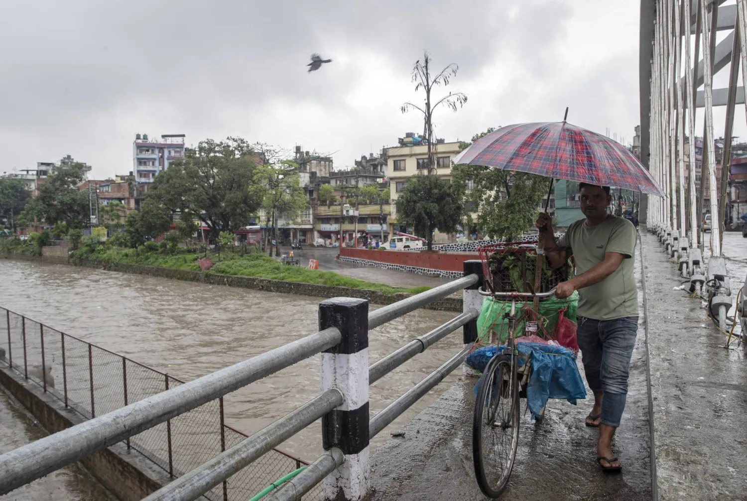 A person crosses a suspension bridge during monsoon rainfall in Kathmandu, Nepal, 11 July 2024. EPA/NARENDRA SHRESTHA