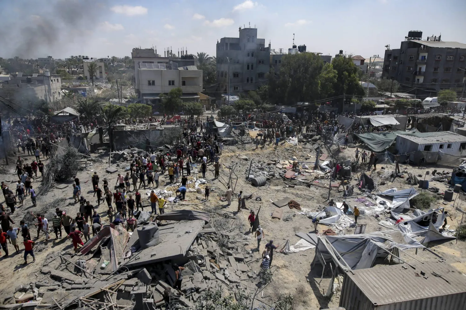 Palestinians inspect the damage at a site hit by an Israeli bombardment on Khan Younis, southern Gaza Strip, Saturday, July 13, 2024. (AP Photo/Jehad Alshrafi)
