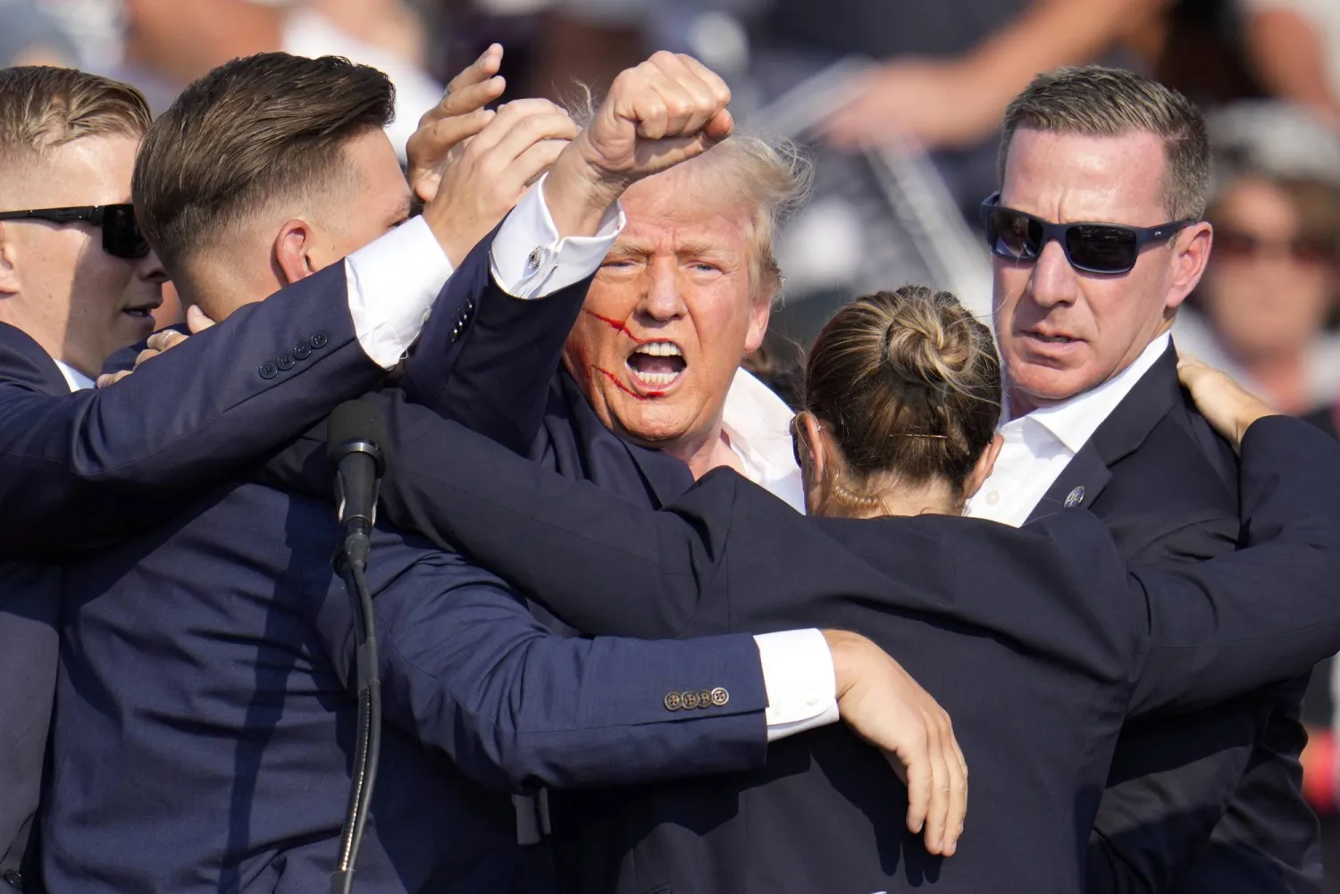 Republican presidential candidate former President Donald Trump is helped off the stage by US Secret Service agents at a campaign event in Butler, Pa., on Saturday, July 13, 2024. (AP Photo/Gene J. Puskar)