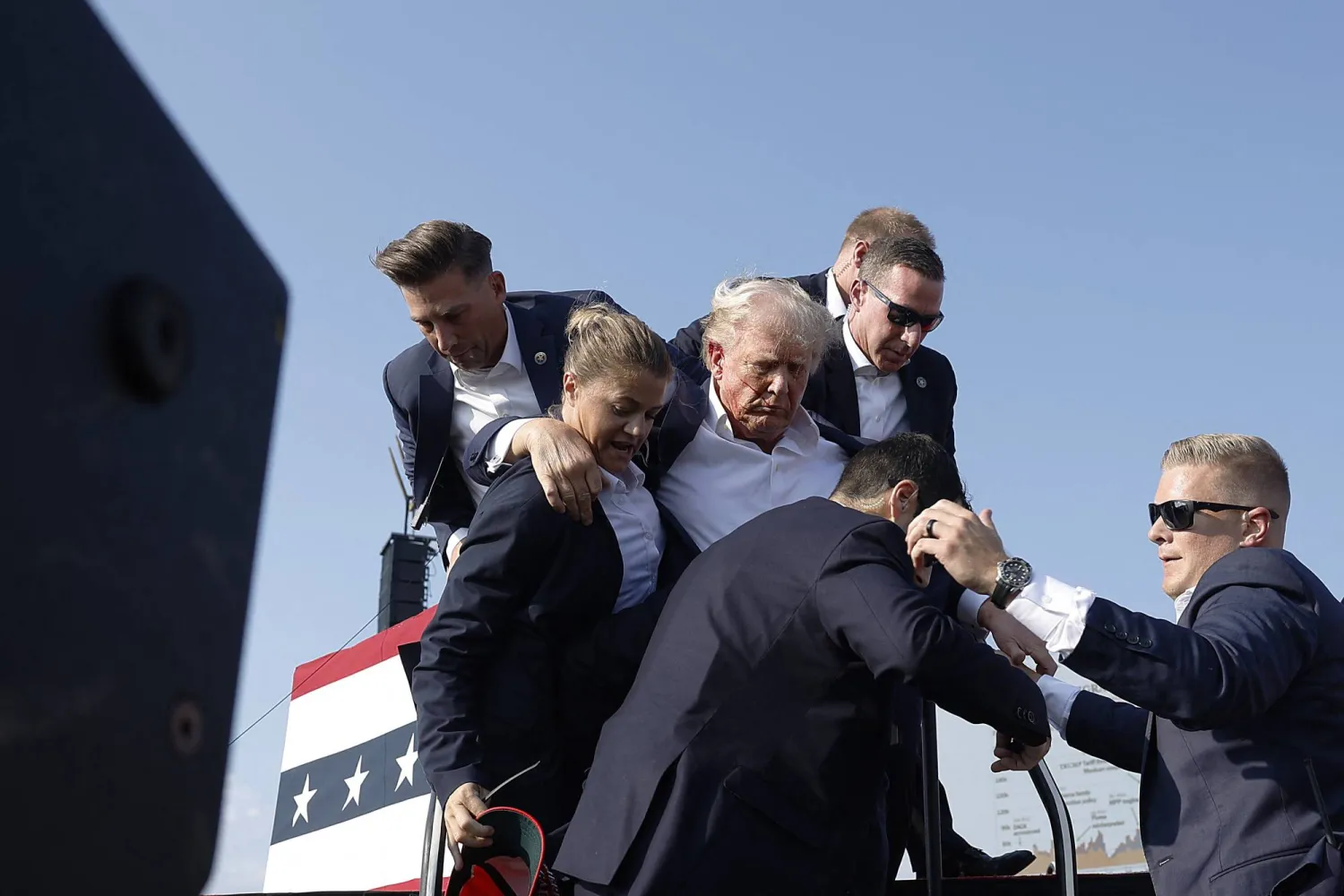 Republican presidential candidate former President Donald Trump pumps his fist as he is rushed offstage during a rally on July 13, 2024 in Butler, Pennsylvania. Anna Moneymaker/Getty Images/AFP
