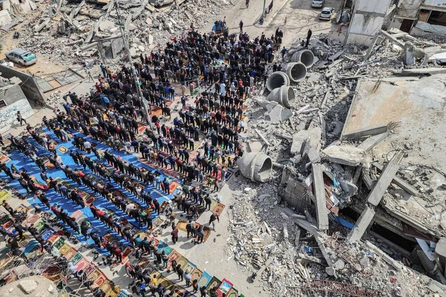In this aerial view, Palestinians attend the Friday noon prayers in front of the ruins of the al-Faruq mosque, destroyed in Israeli strikes in Rafah in the southern Gaza Strip on March 1, 2024, amid continuing battles between Israel and the Palestinian militant group Hamas. (AFP)
