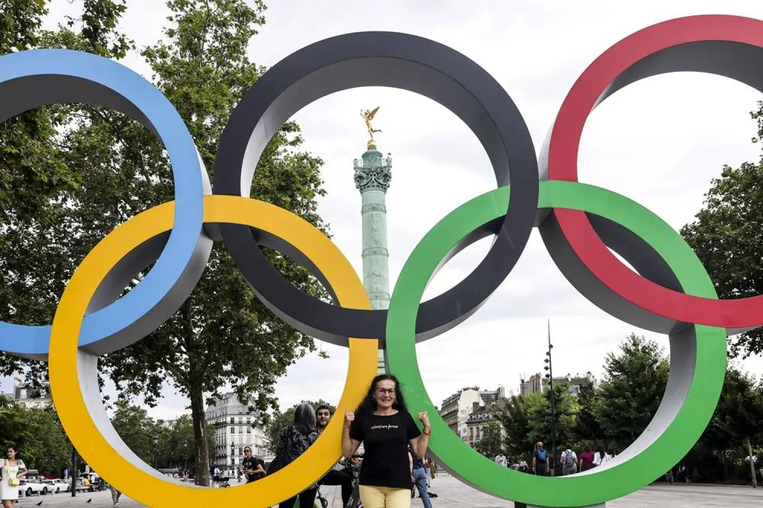A person takes a picture with the Olympic Games logo at the Bastille square in Paris, France, 15 July 2024. (EPA)