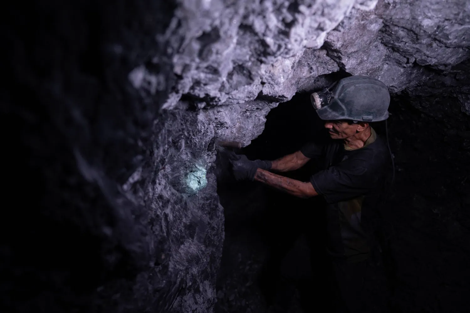دق المطارق في الأنفاق المحفورة تحت مئات الأقدام في الأرض بحثاً عن شيء لامع وأخضر (أ.ف.ب)