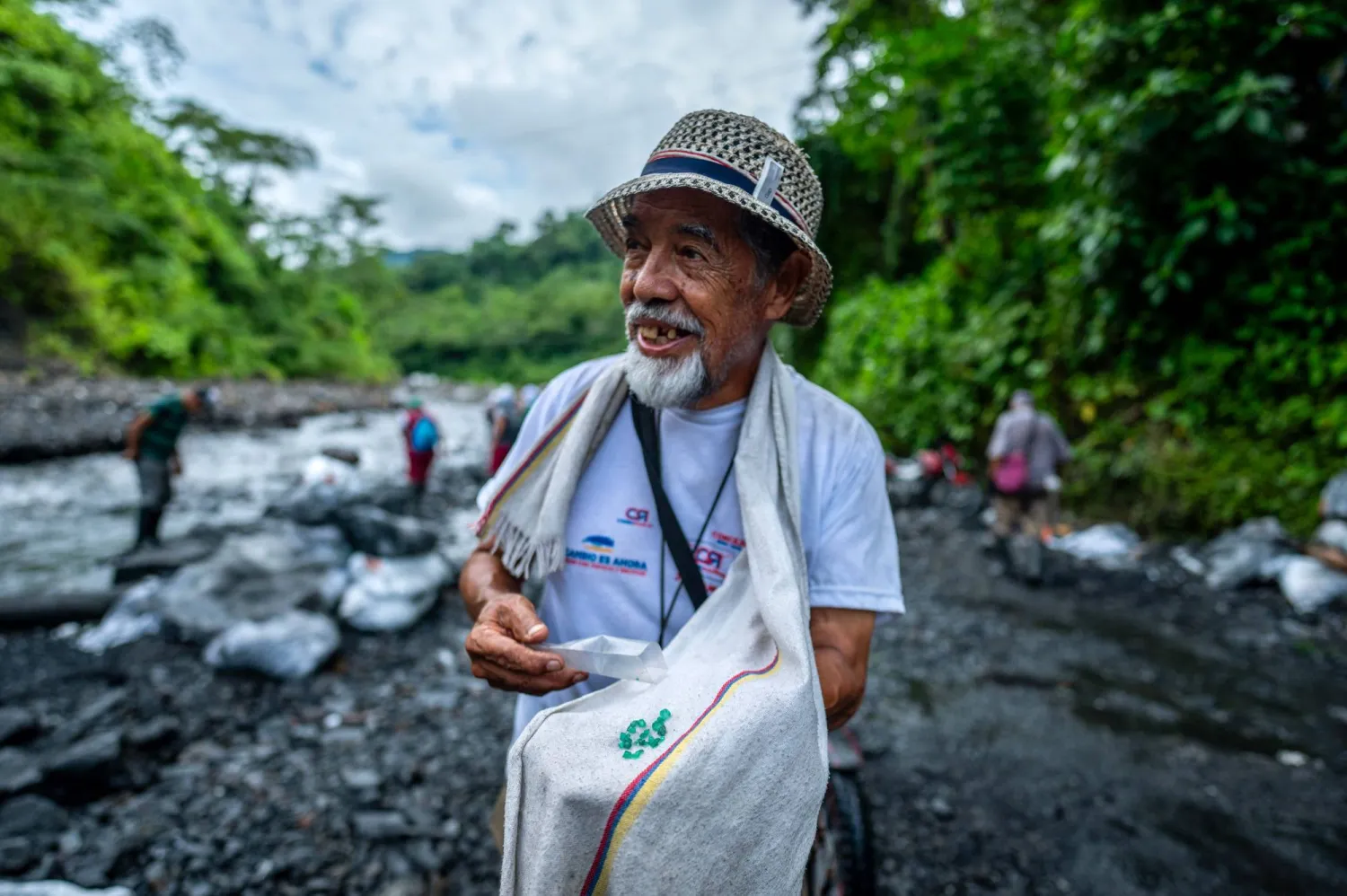 عامل يحمل الأحجار الخضراء فوق قطعة قماش بيضاء (أ.ف.ب)