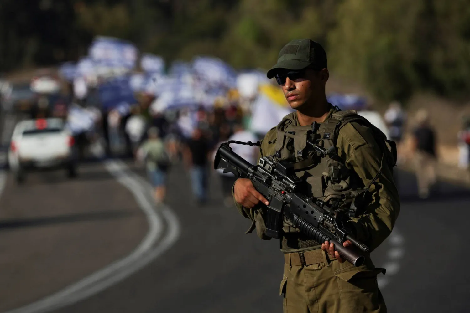 جندي إسرائيلي يظهر وسط مظاهرة في جنوب البلاد (رويترز)