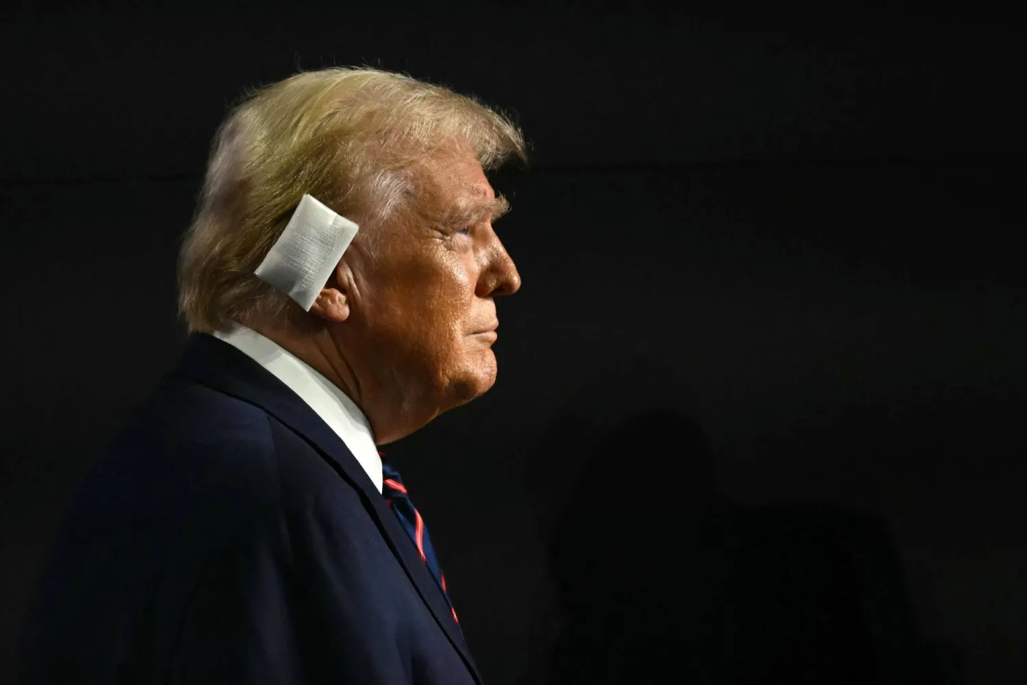 يحضر الرئيس الأميركي السابق والمرشح الرئاسي الجمهوري لعام 2024 دونالد ترامب اليوم الثالث من المؤتمر الوطني للحزب الجمهوري لعام 2024 في منتدى فيسيرف في ميلوكي بضمادة كبيرة على أذنه (أ.ف.ب)
