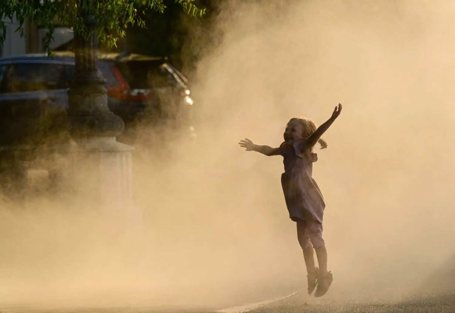 طفلة تقفز وسط ضباب نافورة وسط بوخارست عاصمة رومانيا التي تشهد موجة حارة. ووصلت درجات الحرارة إلى 42 درجة مئوية في المناطق الجنوبية من البلاد (أ.ف.ب)