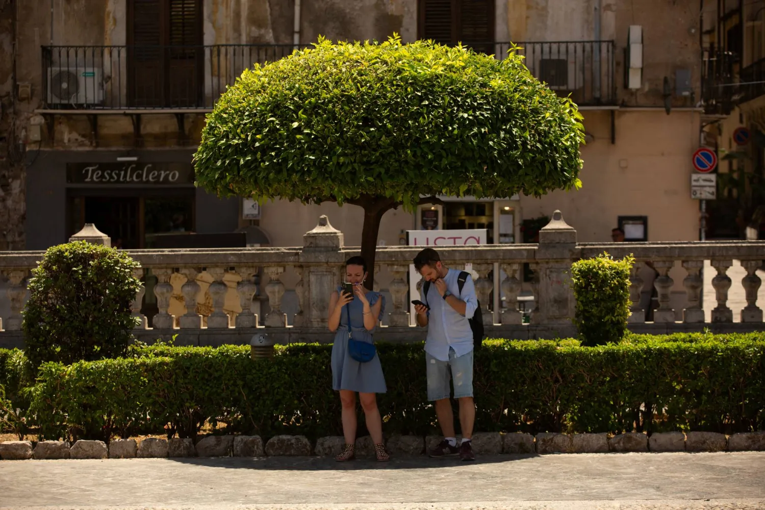 زوجان يحتميان تحت ظل شجرة في صقلية (رويترز)
