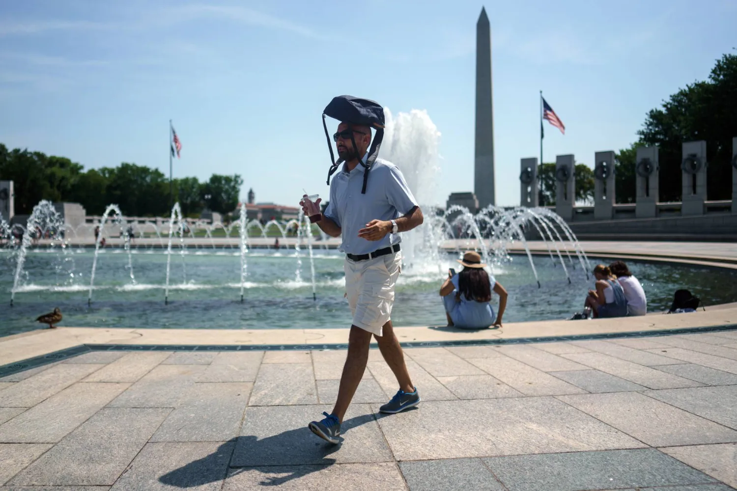 رجل يغطي رأسه بحقيبته في واشنطن (إ.ب.أ)