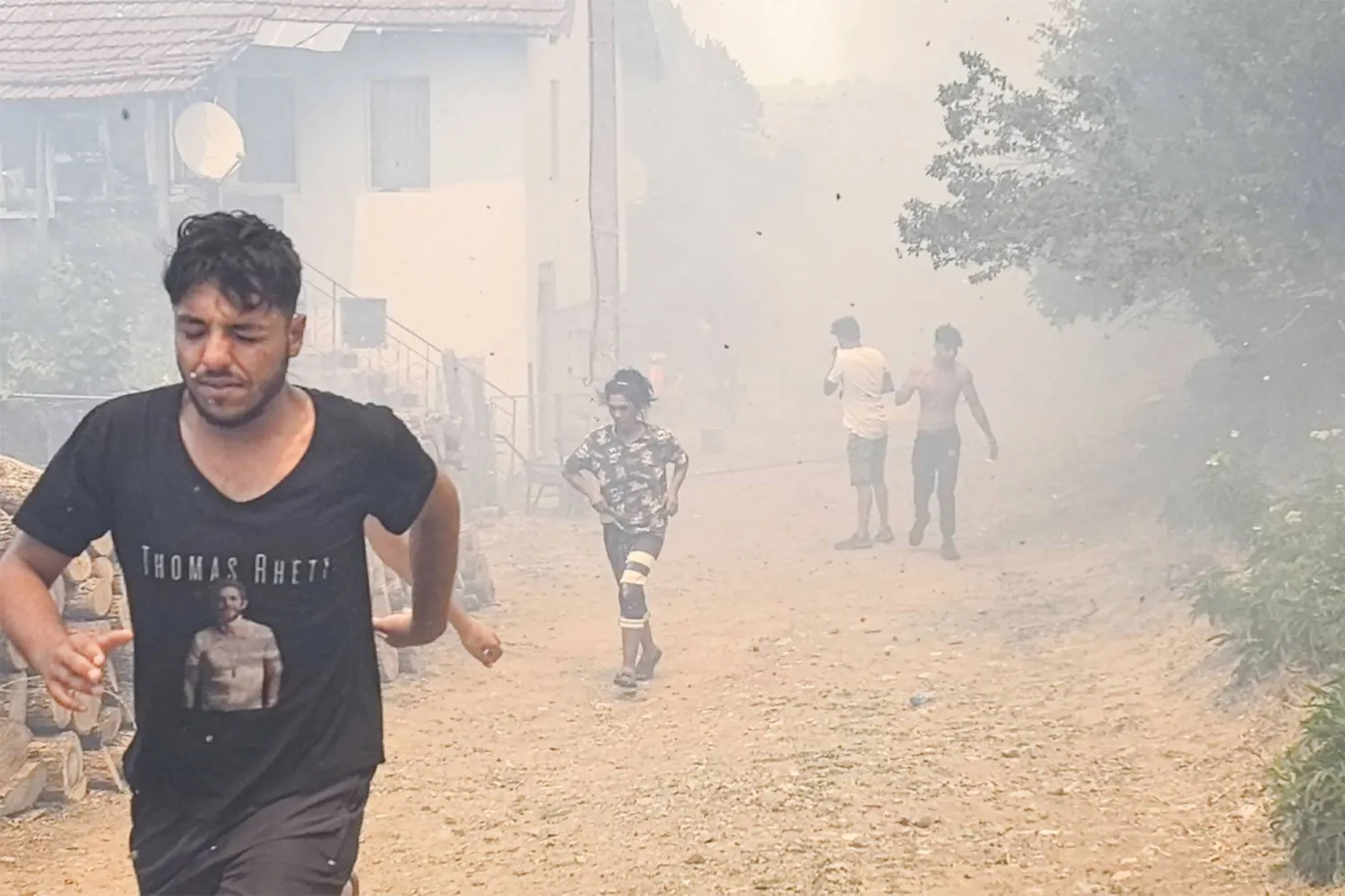 أشخاص يركضون بعد أن اجتاح حريق غابات قرية فودين في جنوب شرقي بلغاريا بسبب الحرارة (أ.ف.ب)