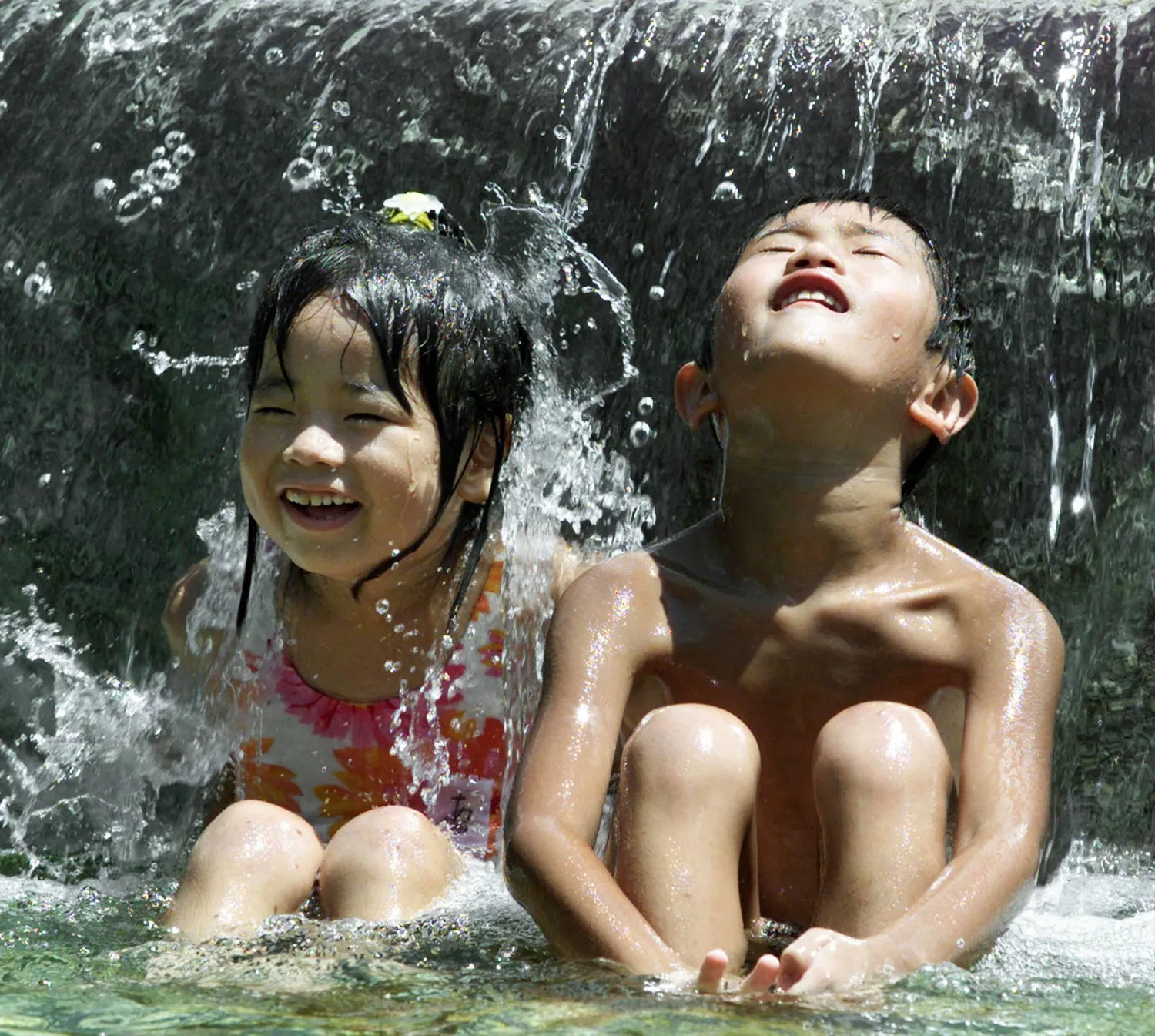 أطفال يابانيون يستمتعون بالاستحمام في حديقة مائية بوسط مدينة طوكيو (إ.ب.أ)