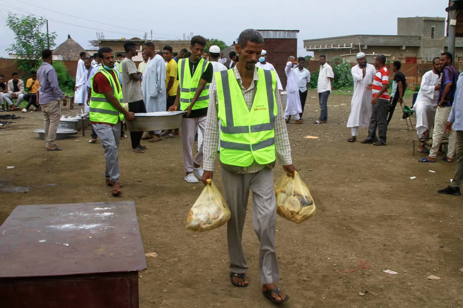 متطوعون يحملون وجبات غذائية لمخيم نازحين في القضارف شرقي السودان... 13 يوليو 2024 (أ.ف.ب)