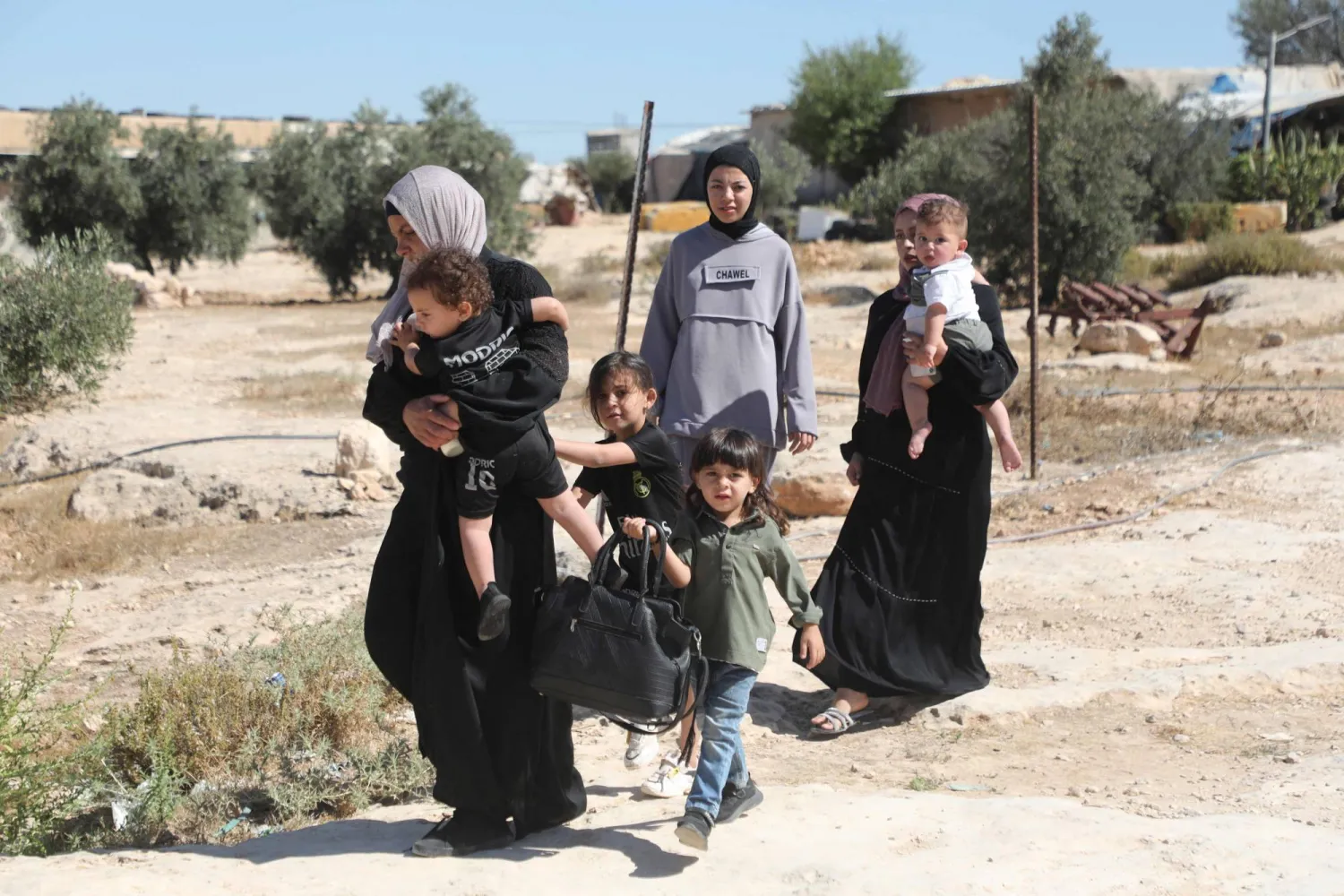 فلسطينيون يسيرون في قرية سوسيا جنوب الضفة الغربية المحتلة (أ.ف.ب)