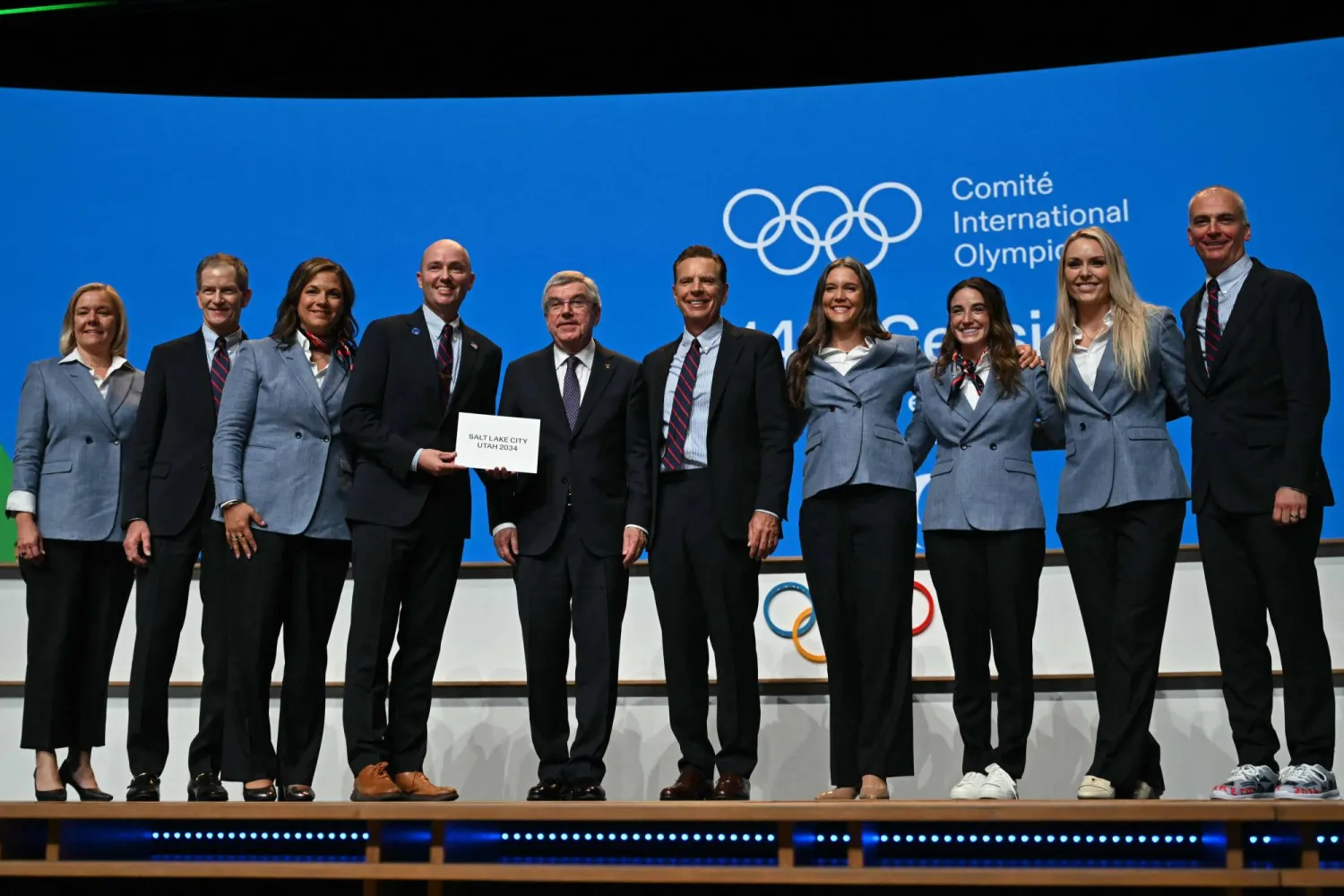 وفد مدينة سولت لايك سيتي يلتقط صورة مع باخ بعد فوزه باستضافة الألعاب الأولمبية الشتوية لعام 2034 (أ.ف.ب)