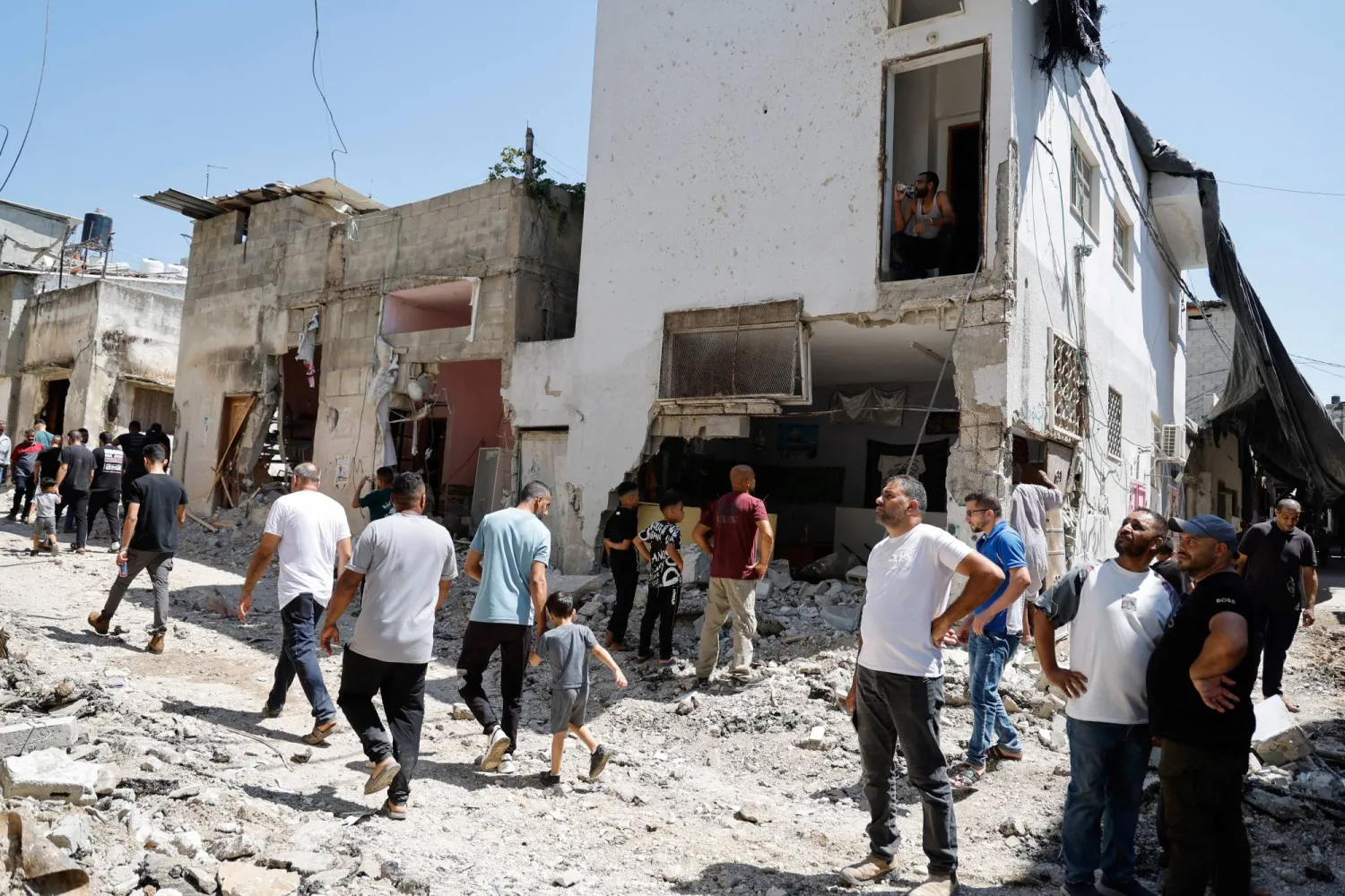 فلسطينيون يتفقدون الأضرار الناجمة عن غارة إسرائيلية في طولكرم بالضفة الغربية (رويترز)