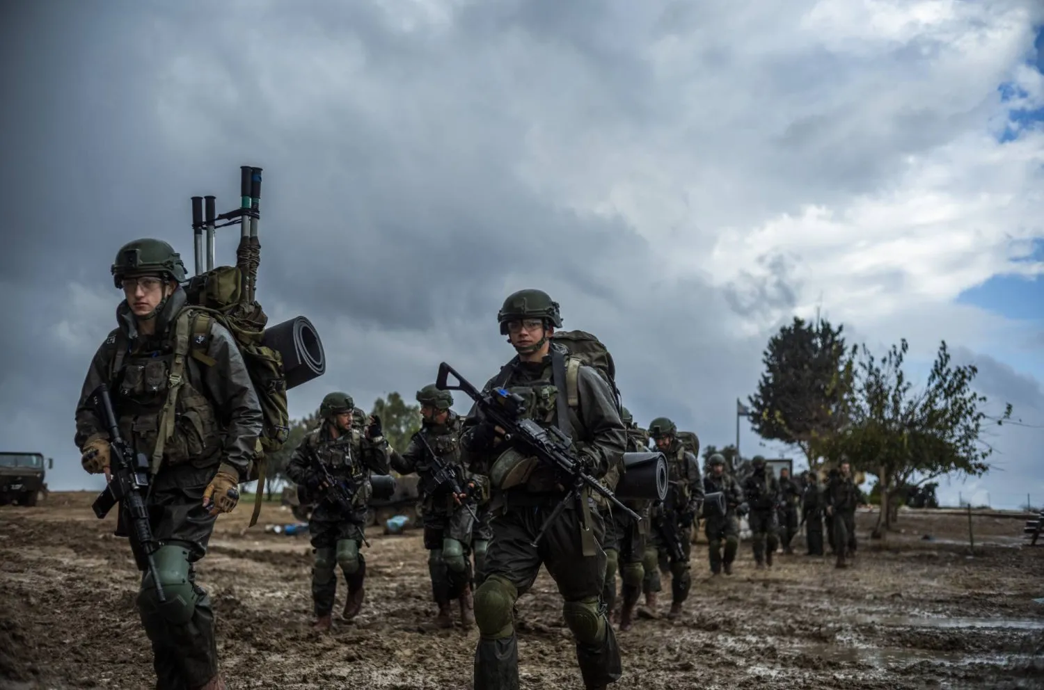 İsrail askerleri, İsrail ile Filistinli Hamas hareketi arasında devam eden çatışmalar sırasında Gazze Şeridi sınırına yakın ilan edilmemiş bir toplanma alanında yürüyor (DPA)