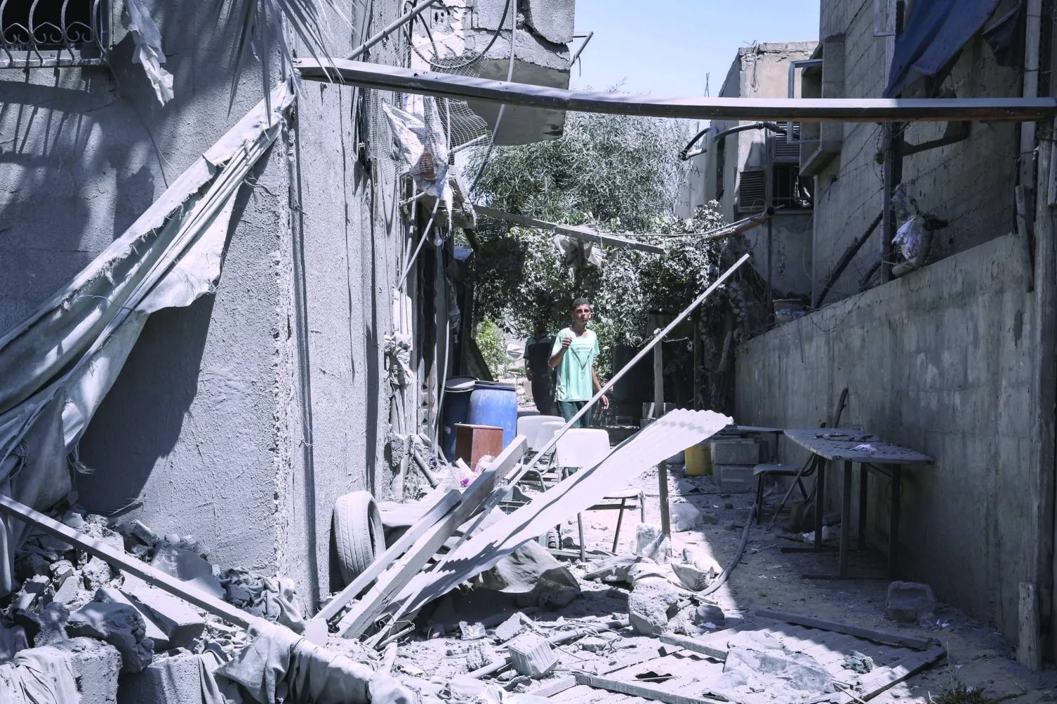  Bir Filistinli, İsrail'in Han Yunus'a düzenlediği baskının ardından yıkılan bir binayı inceliyor (DPA)