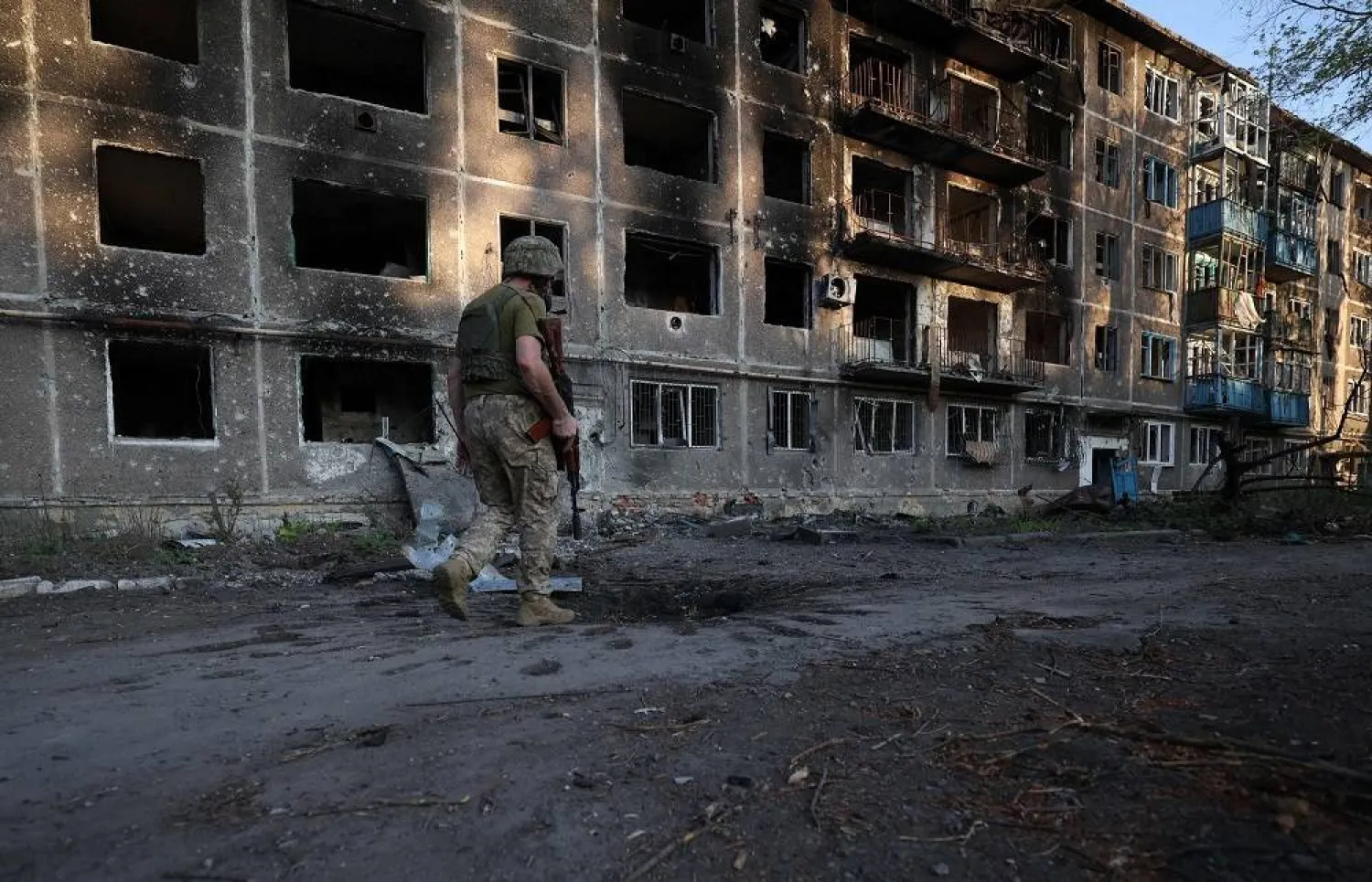 A Ukrainian serviceman of the 225th Separate Assault Battalion patrols as he walks past an apartment building destroyed by artillery fire in the town of Chasiv Yar, Donetsk region, on July 24, 2024, amid the Russian invasion of Ukraine. (AFP)