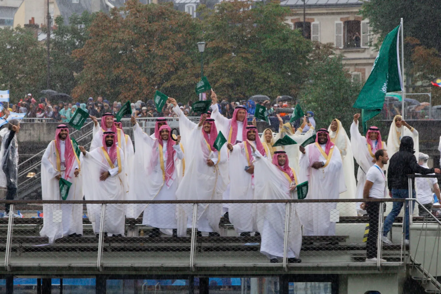 البعثة السعودية تلوح بالأعلام الخضراء خلال مسيرة الدول المشاركة (الأولمبية السعودية)