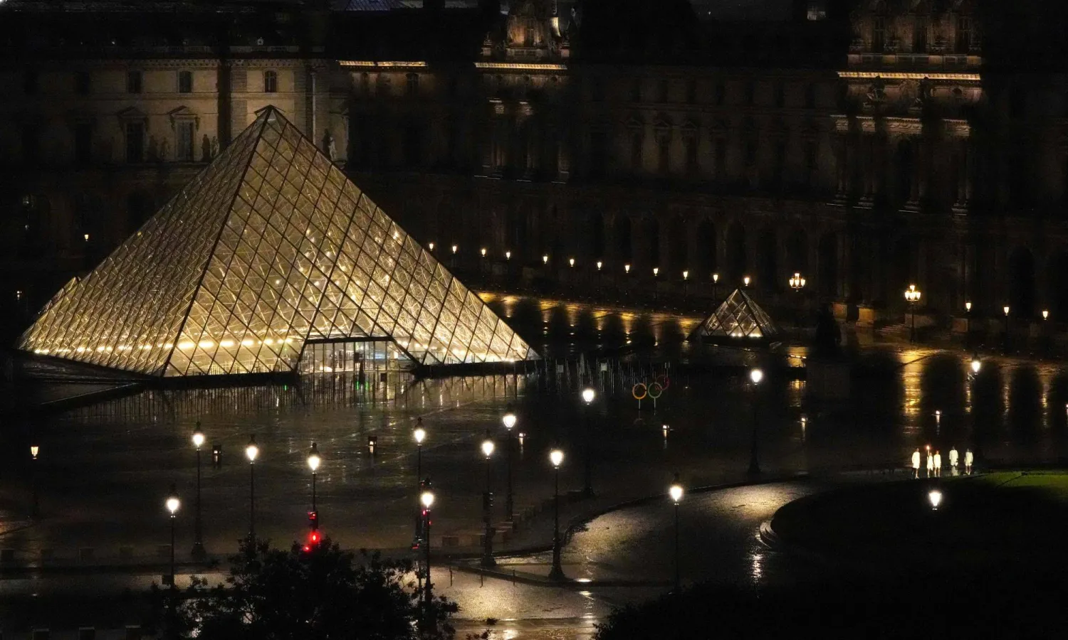 حاملو الشعلة في متحف «اللوفر» خلال حفل افتتاح دورة الألعاب الأولمبية 2024 في باريس (أ.ف.ب)