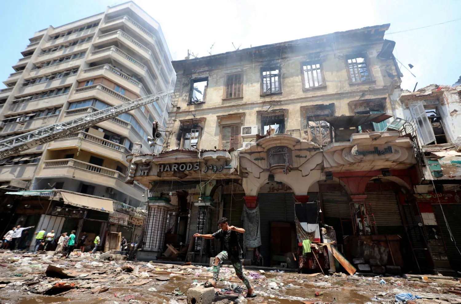 مصري يسير بالقرب من المتاجر المتضررة في الحريق الذي شهدته منطقة «الموسكي» (رويترز)