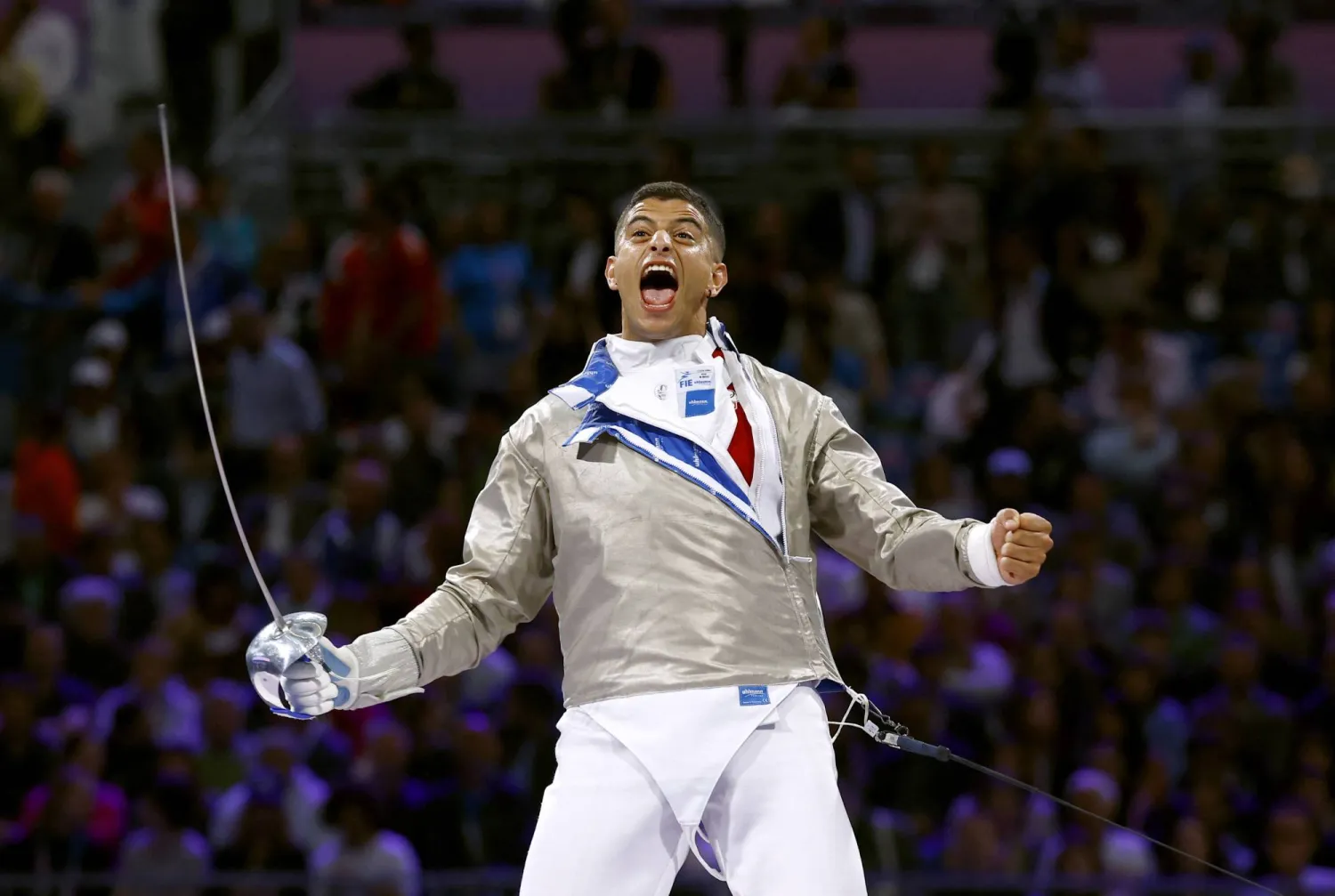 فرحة التونسي فارس فرجاني عقب فوزه على المصري زياد السيسي في المبارزة بالسيف بأولمبياد باريس (رويترز)