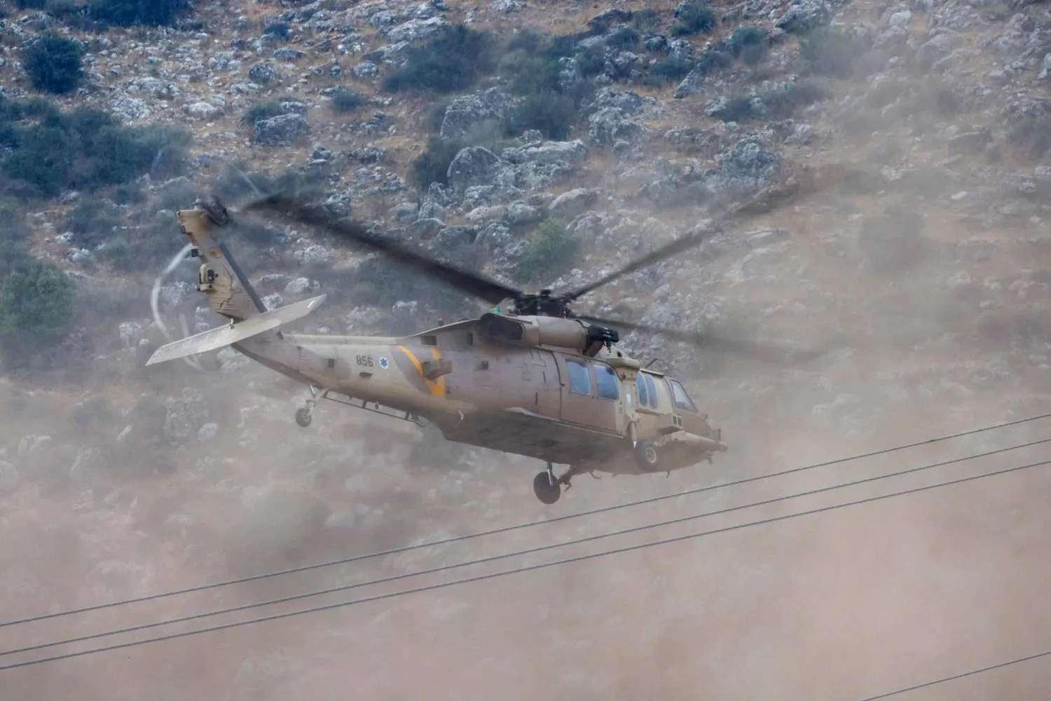 Golan Tepeleri'nde roketin düştüğü yerin yakınında uçan bir İsrail helikopteri (AFP)