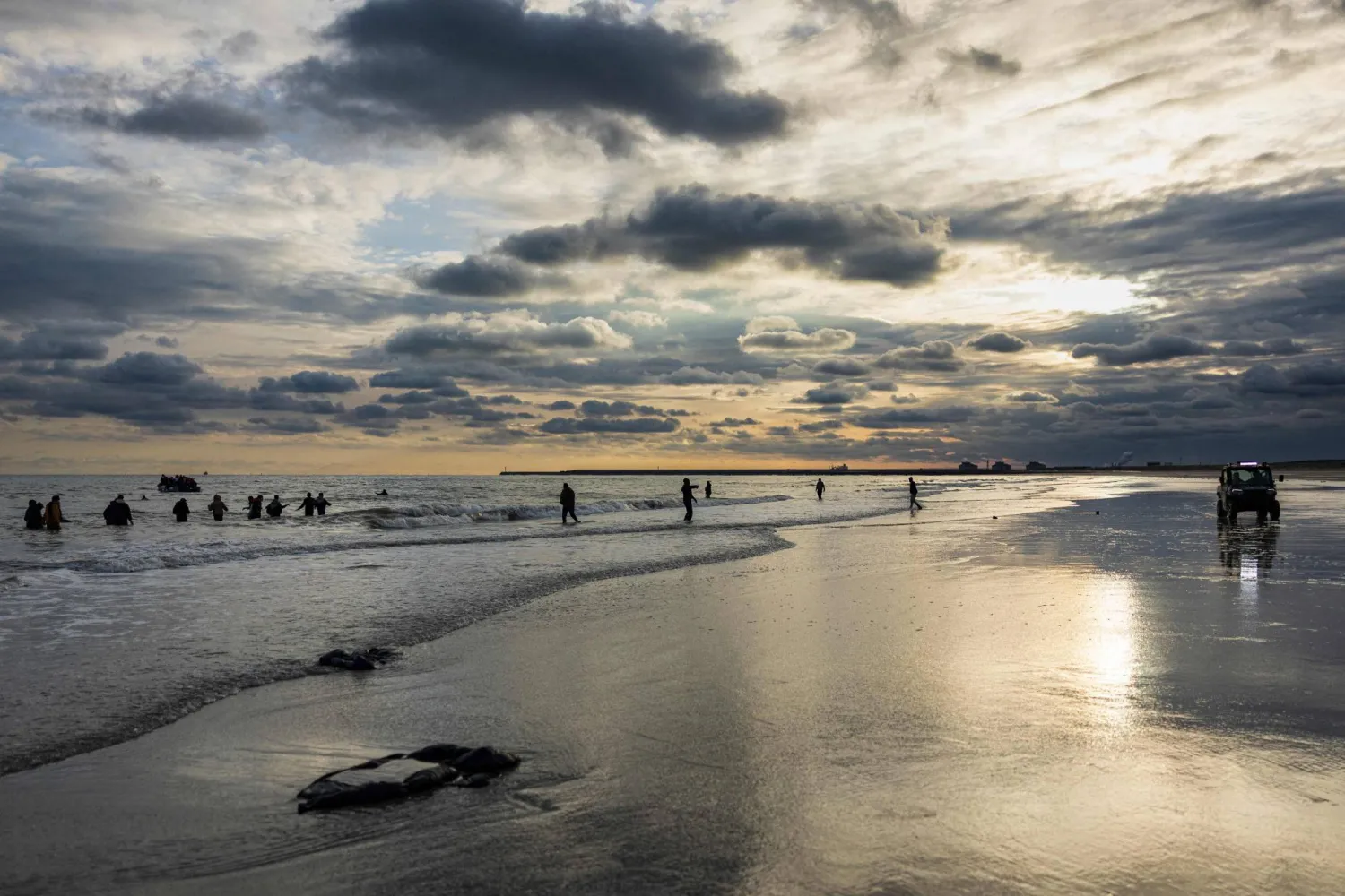 Migrants try to board a smuggler's boat in an attempt to cross the English Channel, on the beach of Gravelines, near Dunkirk, northern France on April 26, 2024. (Photo by Sameer Al-DOUMY / AFP)