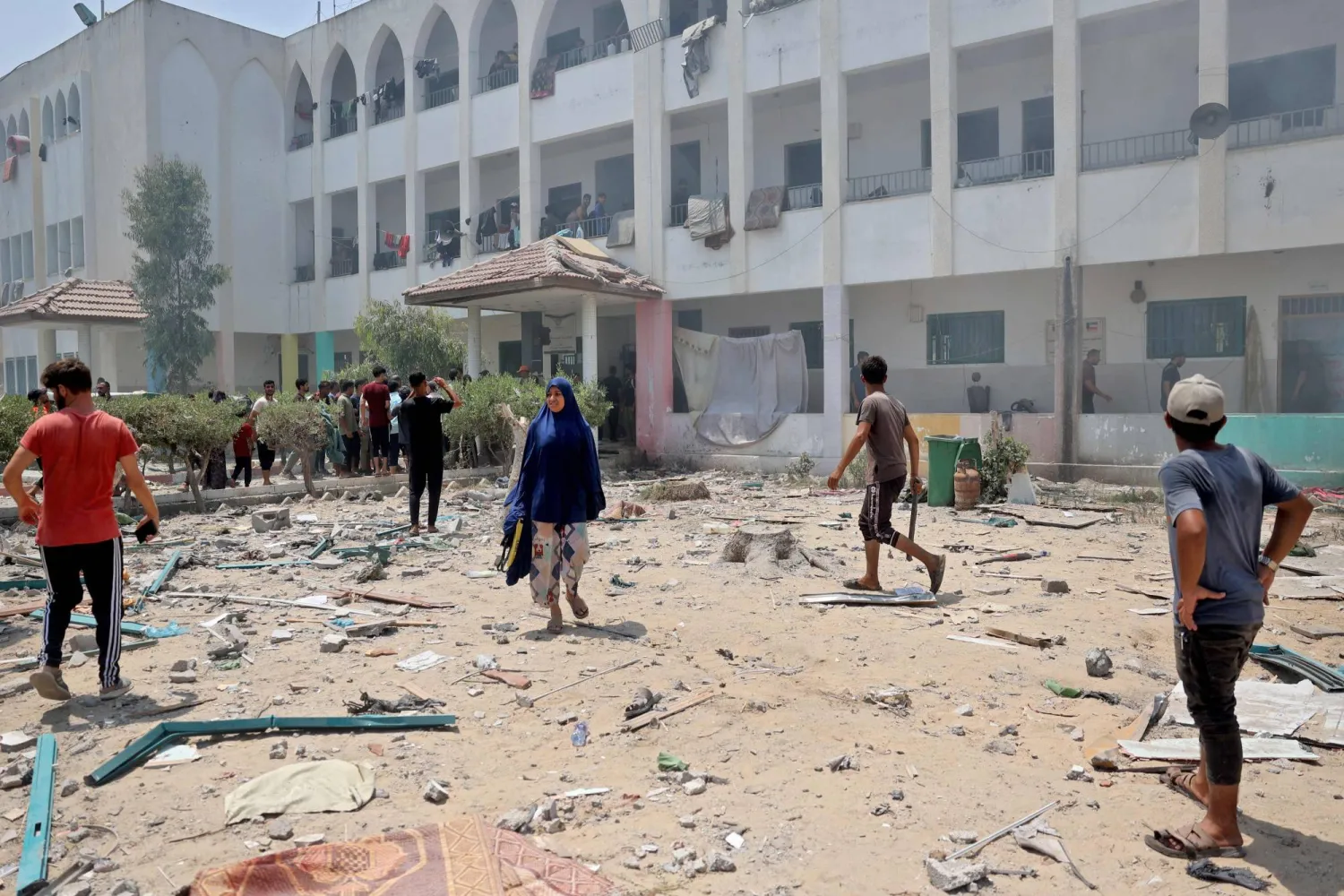 Palestinians inspect the damage following an Israeli strike on the Khadija school housing displaced people in Deir al-Balah, in the central Gaza Strip on July 27, 2024. (Photo by Eyad BABA / AFP)