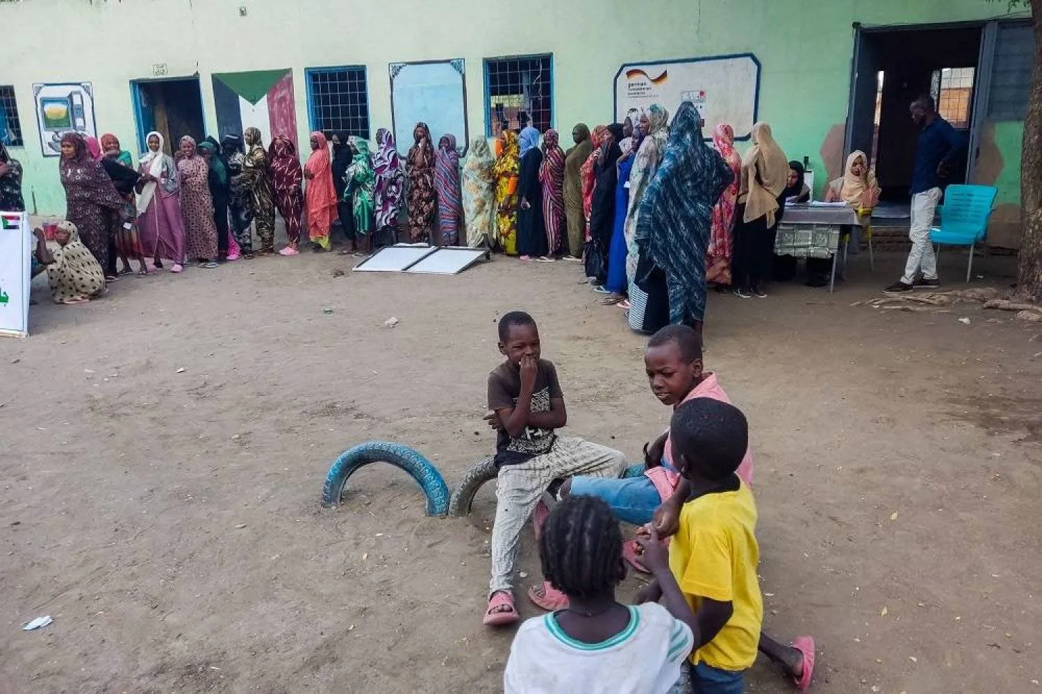 Internally displaced women wait in a queue to collect aid from a group at a camp in Gadaref on May 12, 2024. (AFP)
